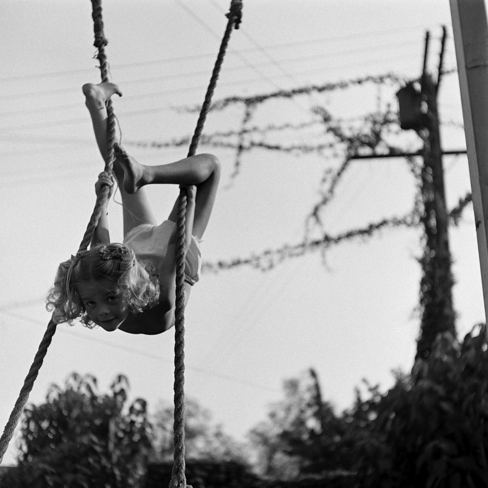 Natalie Wood swings upside down in her backyard as a child