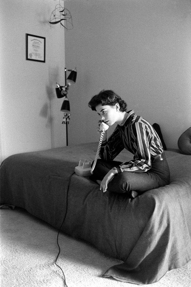 Natalie Wood takes a call while sitting on her bed at home in 1965.