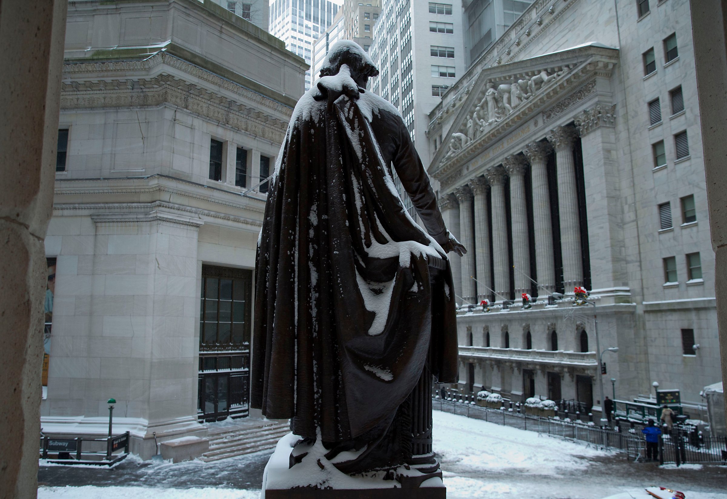The George Washington statue stands covered in snow near the New York Stock Exchange (NYSE) in New York, U.S. Wind-driven snow whipped through New Yorks streets and piled up in Boston as a fast-moving storm brought near-blizzard conditions to parts of the Northeast, closing roads, grounding flights and shutting schools.