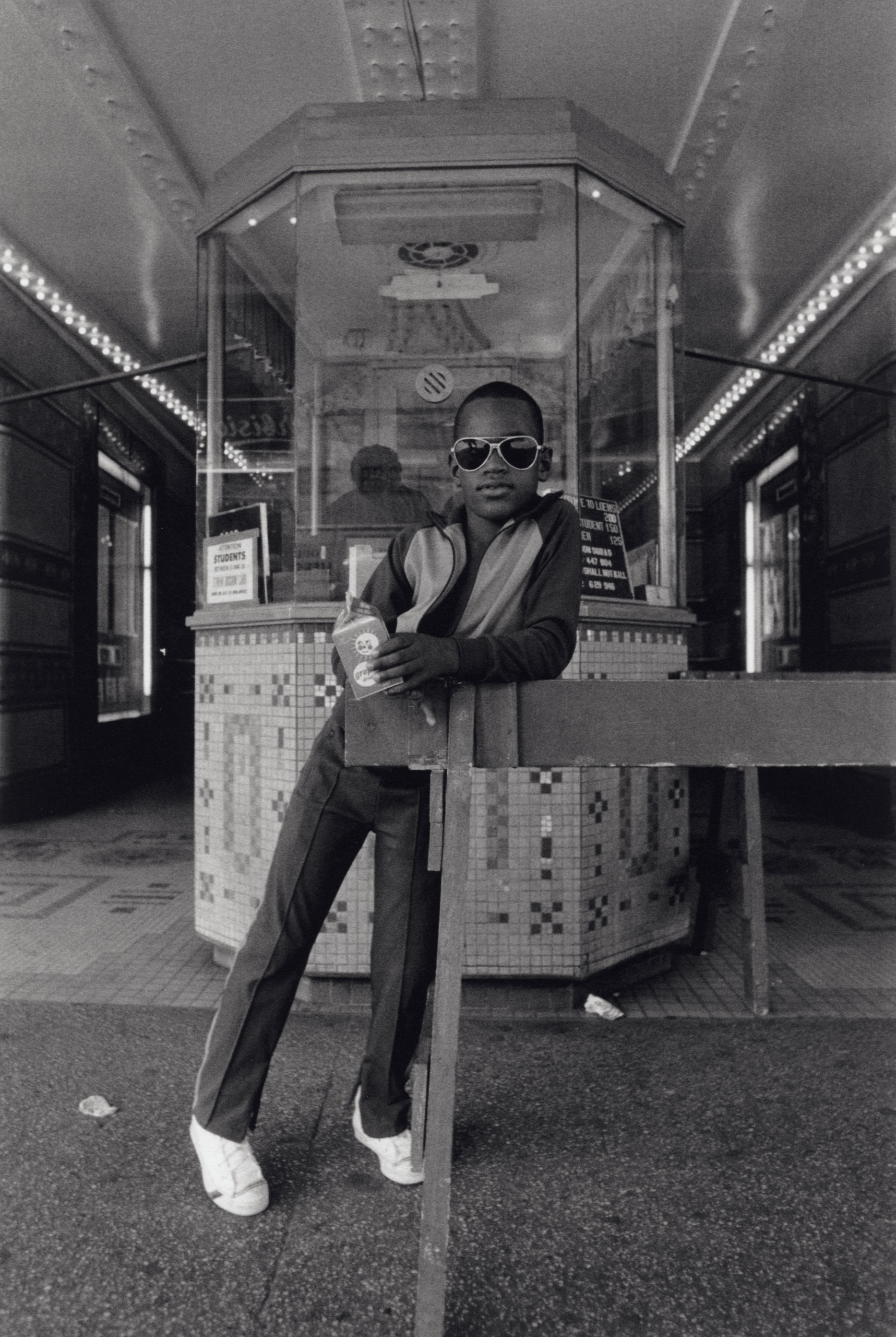 A boy in front of the Loews 125th Street movie theater, 1976.