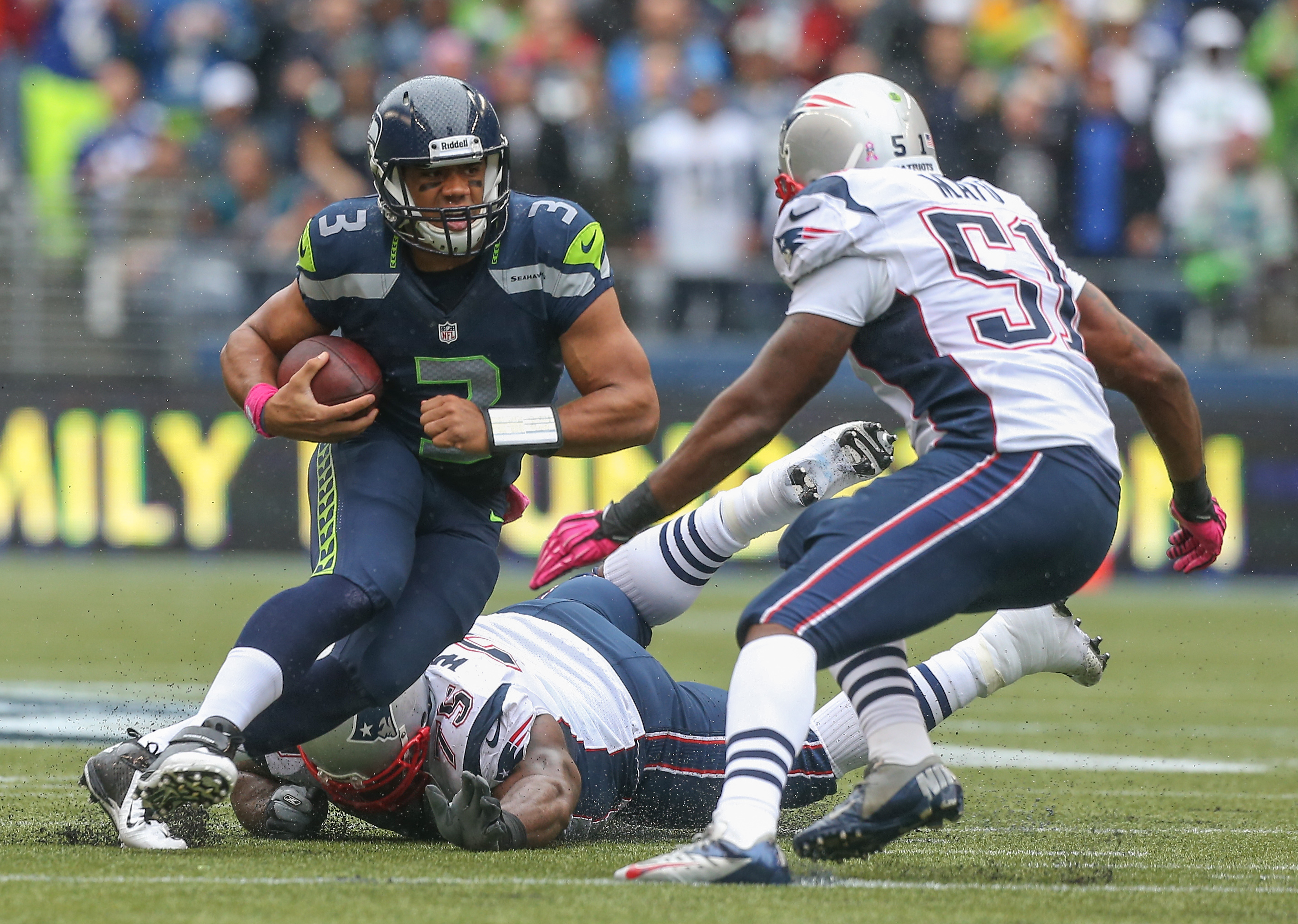 Quarterback Russell Wilson #3 of the Seattle Seahawks rushes against defensive tackle Vince Wilfork #75, and outside linebacker Jerod Mayo #51 of the New England Patriots at CenturyLink Field on October 14, 2012 in Seattle, Washington. (Otto Greule Jr&mdash;Getty Images)