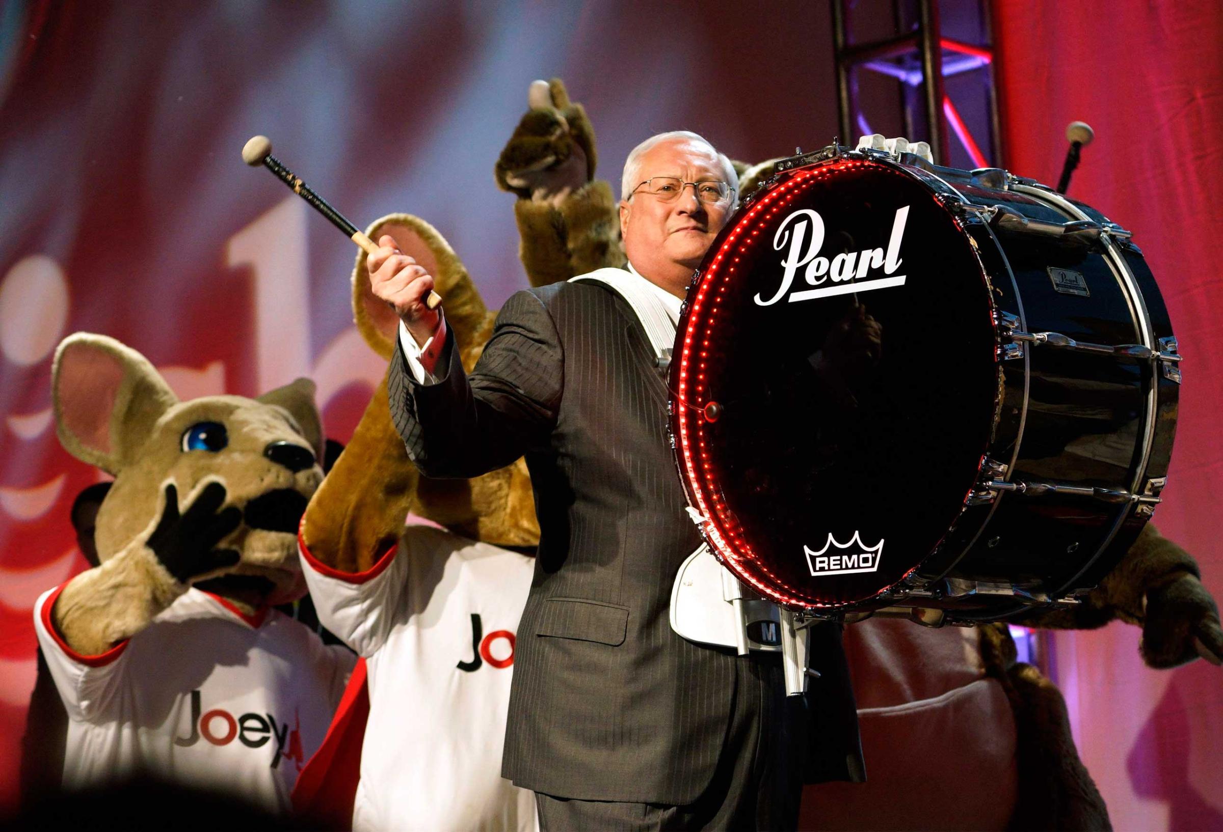 Joe Clayton, CEO of Dish, arrives on stage banging a bass drum followed by company mascots during the Dish news conference at the International Consumer Electronics show (CES) in Las Vegas on Jan. 5, 2015.