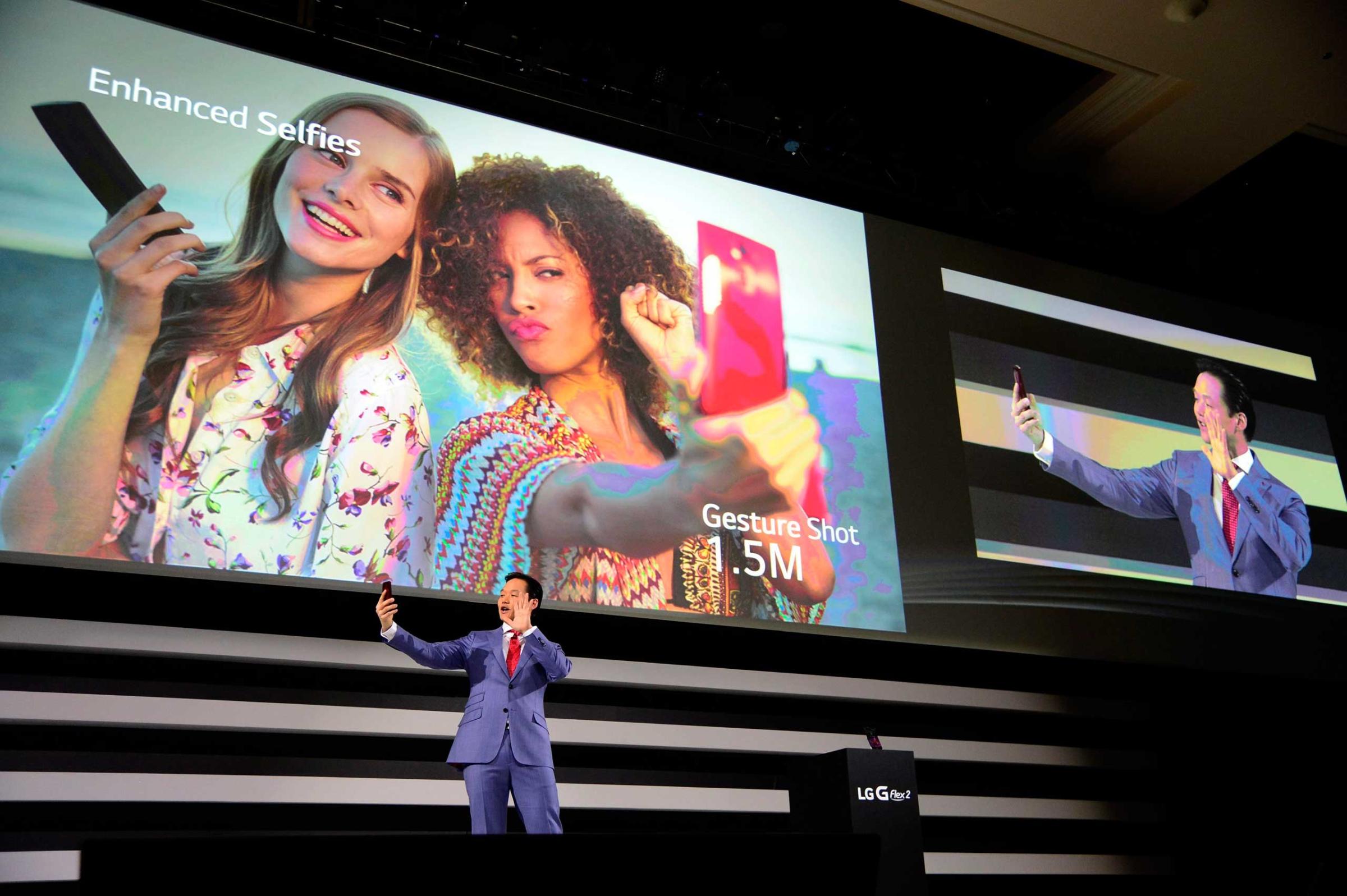 Frank Lee, Brand Marketing for LG Electronics MobileComm USA, demonstrates the enhanced selfie feature on the new LG G Flex 2 mobile phone on press day for the 2015 International Consumer Electronics Show (CES) at the Mandalay Bay Convention Center in Las Vegas on Jan. 5, 2015.
