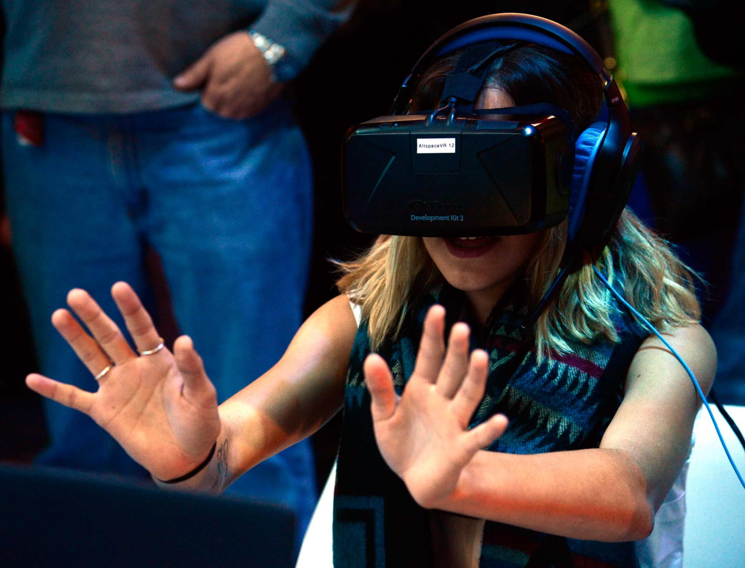 An attendee wears Altspace Virtual Reality head ware on Jan. 6, 2014.
