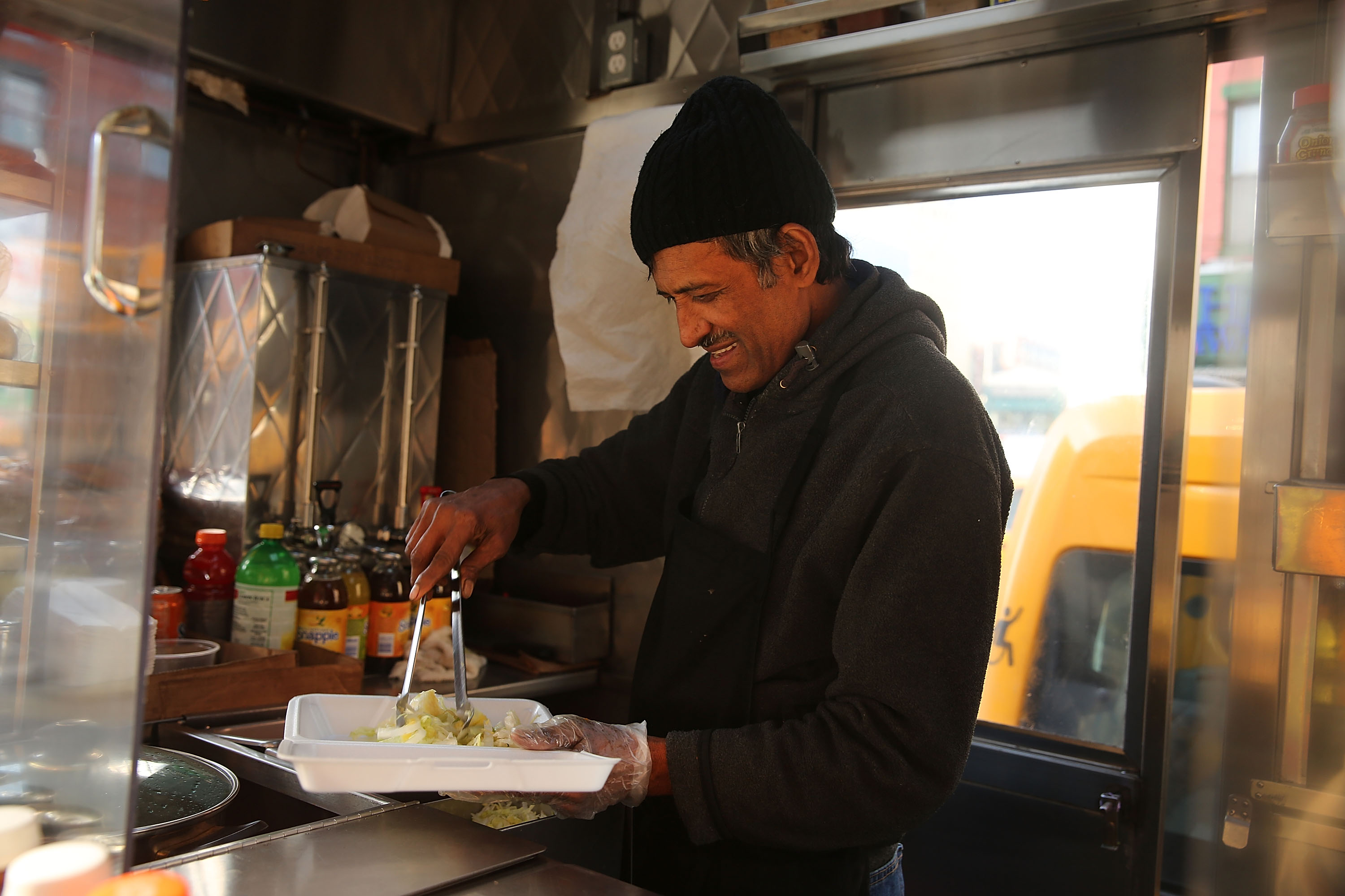 A food cart worker filled a styrofoam take-out container for a customer in New York in 2013. (Spencer Platt—Getty Images)