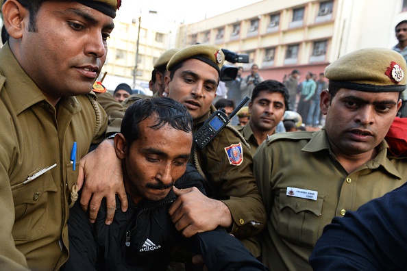 Indian police escort Uber taxi driver and accused rapist Shiv Kumar Yadav, center, following his court appearance in New Delhi on Dec. 8, 2014 (Chandan Khanna—AFP/Getty Images)