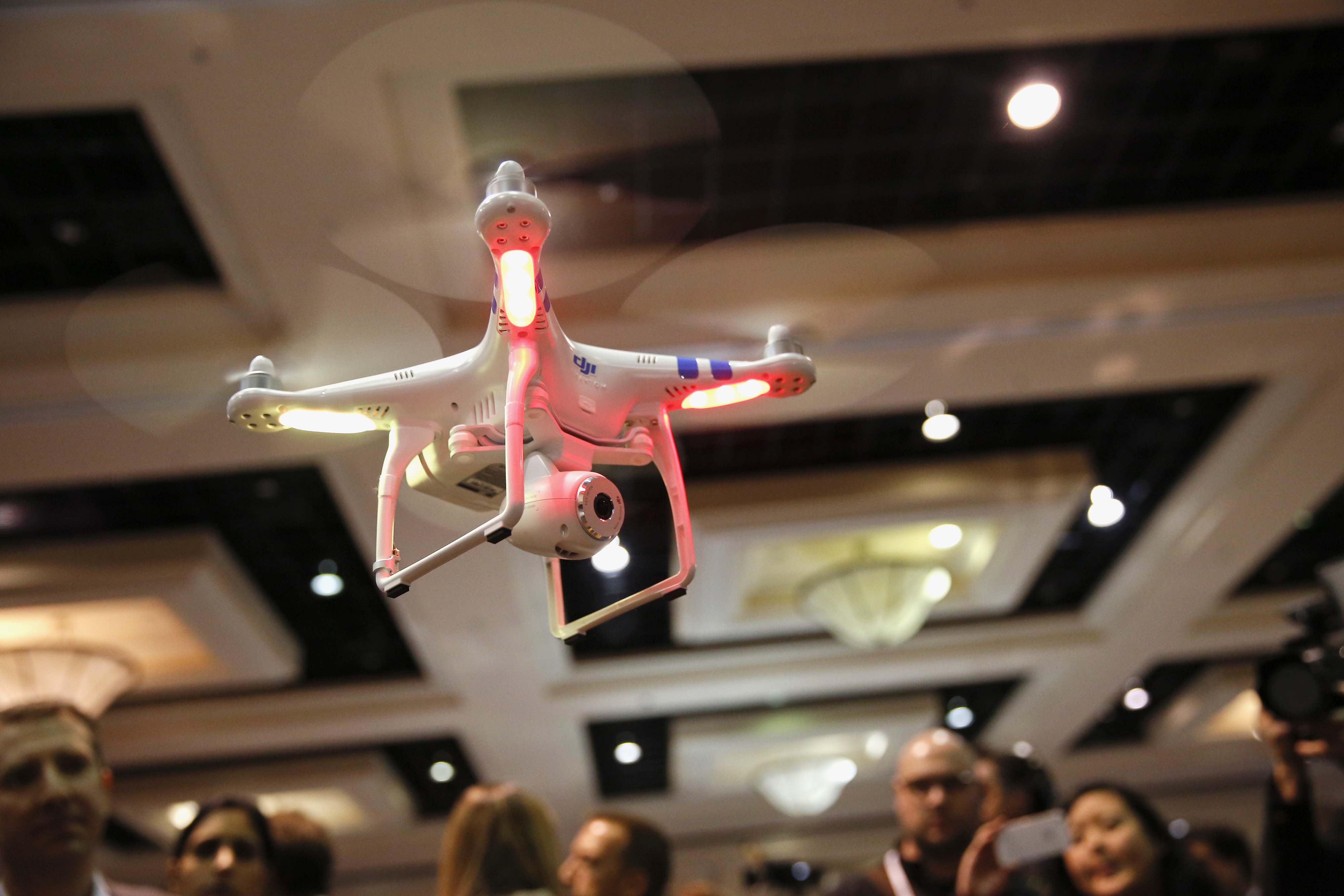 A DJI Innovations Phantom remote-controlled drone hovers above attendees during the CES Unveiled press event prior to the 2014 Consumer Electronics Show in Las Vegas, Nevada, U.S., on Sunday, Jan. 5, 2014. (Bloomberg—Bloomberg via Getty Images)