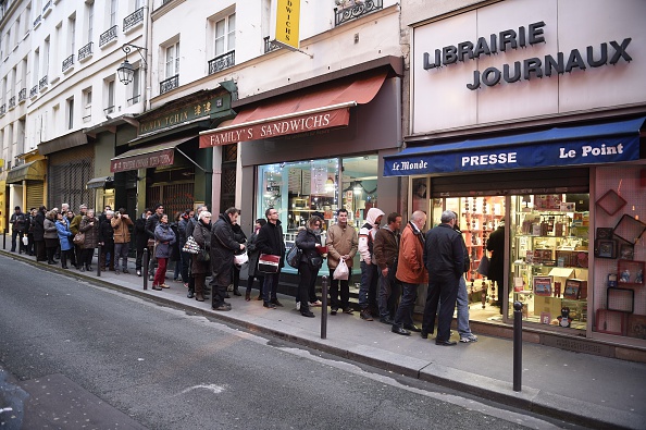 People wait outside a newsagents in Paris on Jan. 14, 2015 as the latest edition of French satirical newspaper Charlie Hebdo goes on sale. (Martin Bureau—AFP/Getty Images)