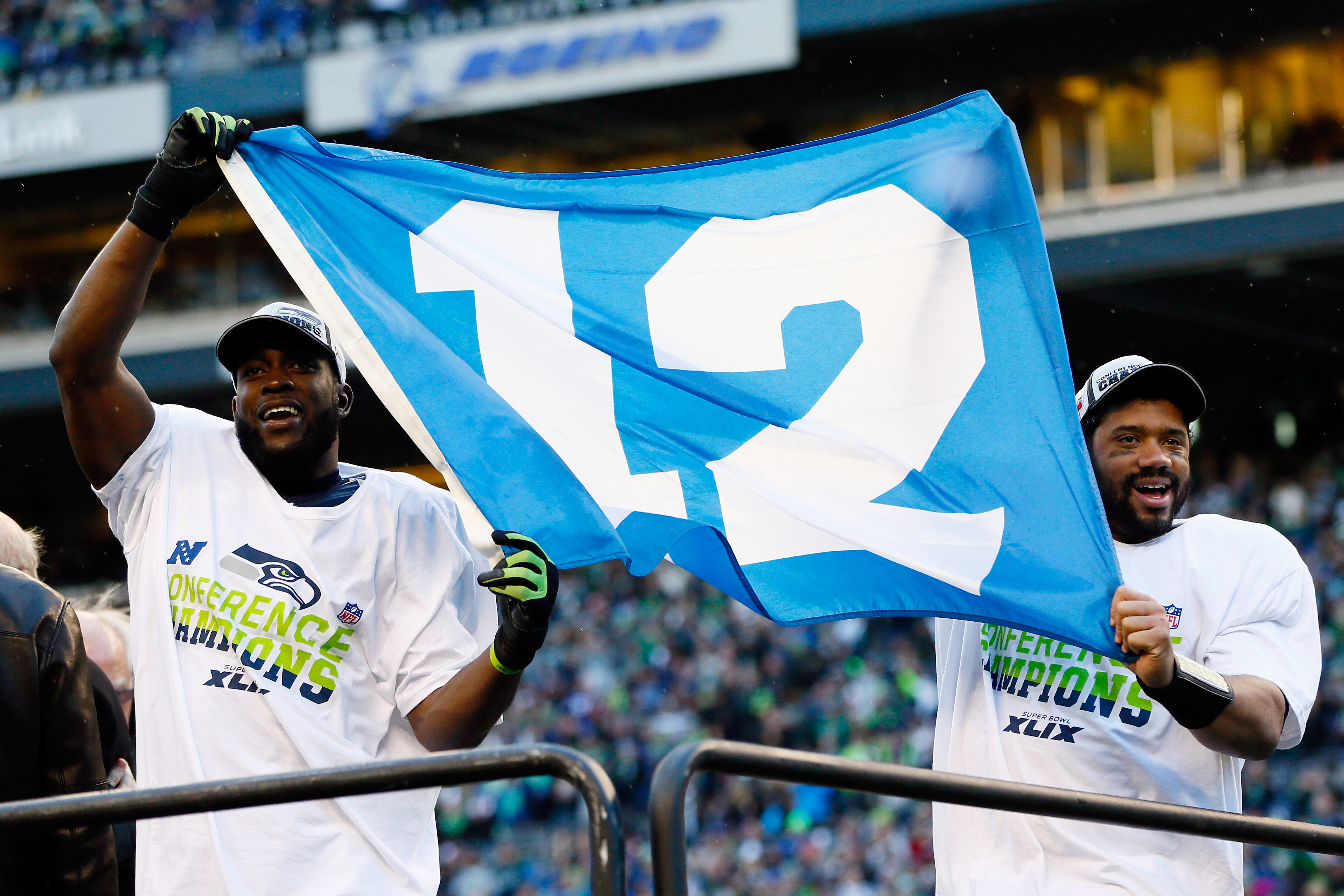 Kam Chancellor (L) and Russell Wilson #3 of the Seattle Seahawks celebrate with a 12th Man flag after defeating the Green Bay Packers in the 2015 NFC Championship game at CenturyLink Field on Jan. 18, 2015 in Seattle, Wash. (Kevin C. Cox—Getty Images)