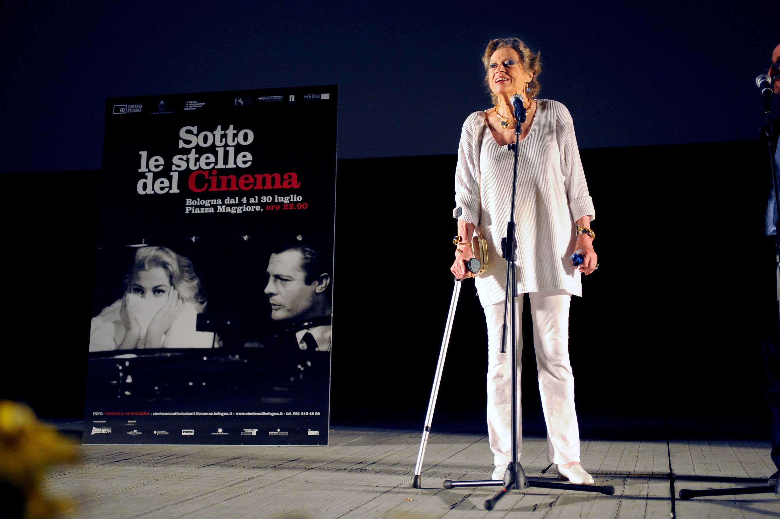 Ekberg attends a screening of the restored version of La Dolce Vita, posing next to a poster featuring herself and co-star Mastroianni ,at the Piazza Maggiore on July 6, 2010 in Bologna.