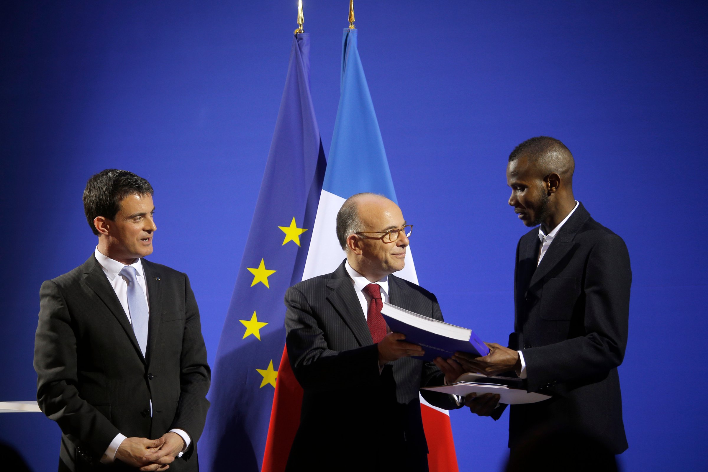 French Prime Minister Manuel Valls (L) and French Interior Minister Bernard Cazeneuve (C) award citizenship to Lassana Bathily in Paris, France, on Jan. 20, 2015.