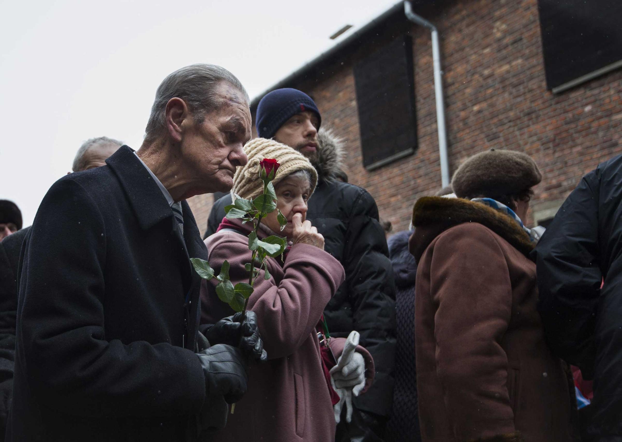 Holocaust survivors pay tribute to fallen comrades at the "death wall" execution spot in the former Auschwitz concentration camp in Oswiecim, on the 70th anniversary of the liberation of the Nazi death camp on Jan. 27, 2015.