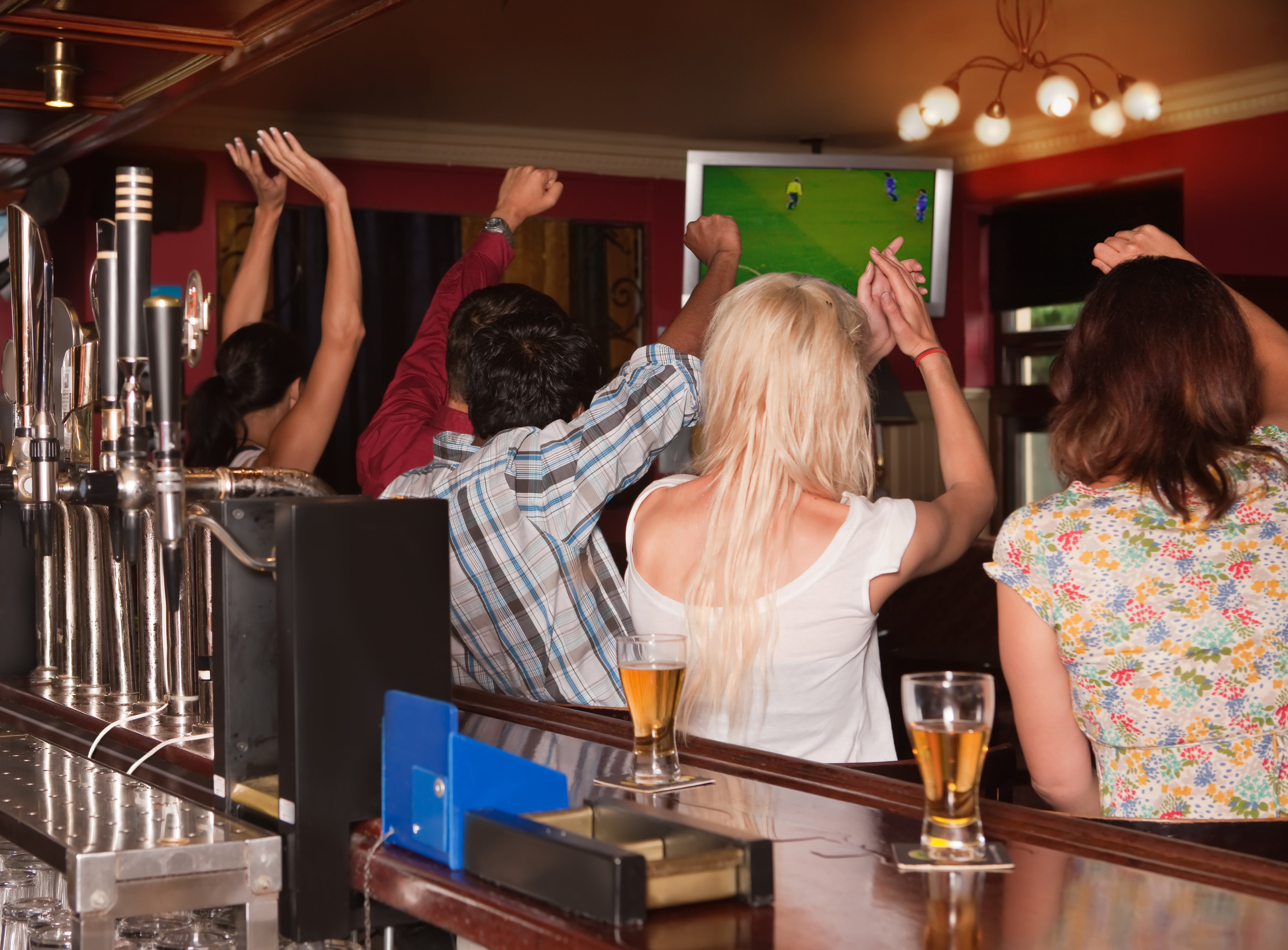 Friends in a pub watching football