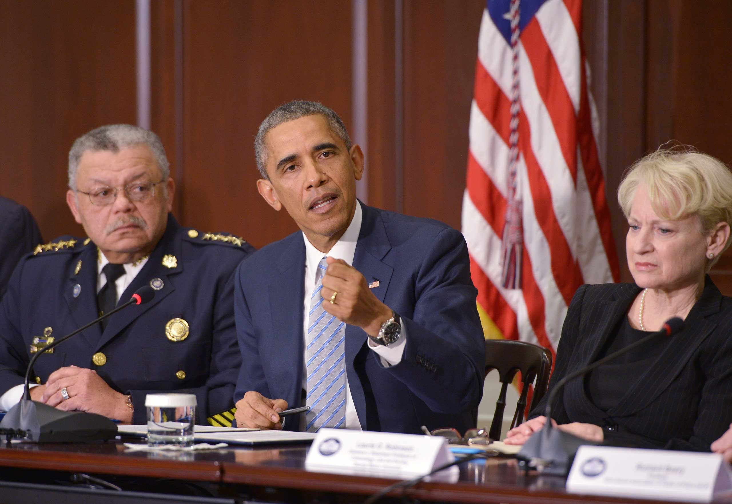US President Barack Obama speaks after a meeting on building trust in communities following Ferguson unrest, with Philadelphia Police Commissioner Charles Ramsey (L) and George Mason University professor of Criminology, Law and Society Laurie Robinson, who were appointed by Obama to chair a task force on policing, at the Eisenhower Executive Office Building in Washington on Dec. 1, 2014. (Mandel Ngan—AFP/Getty Images)