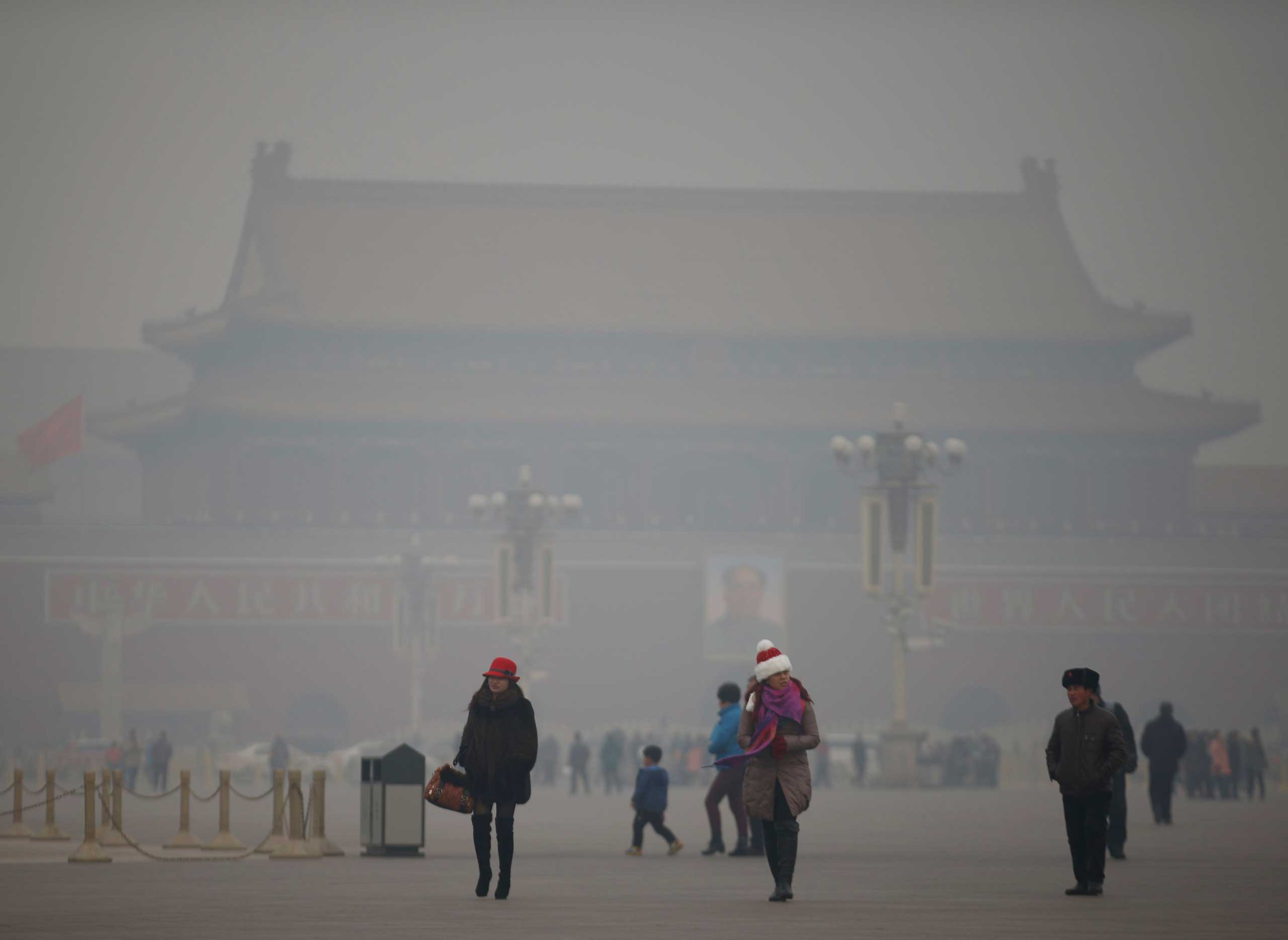 Visitors take a walk during a polluted day at Tiananmen Square in Beijing