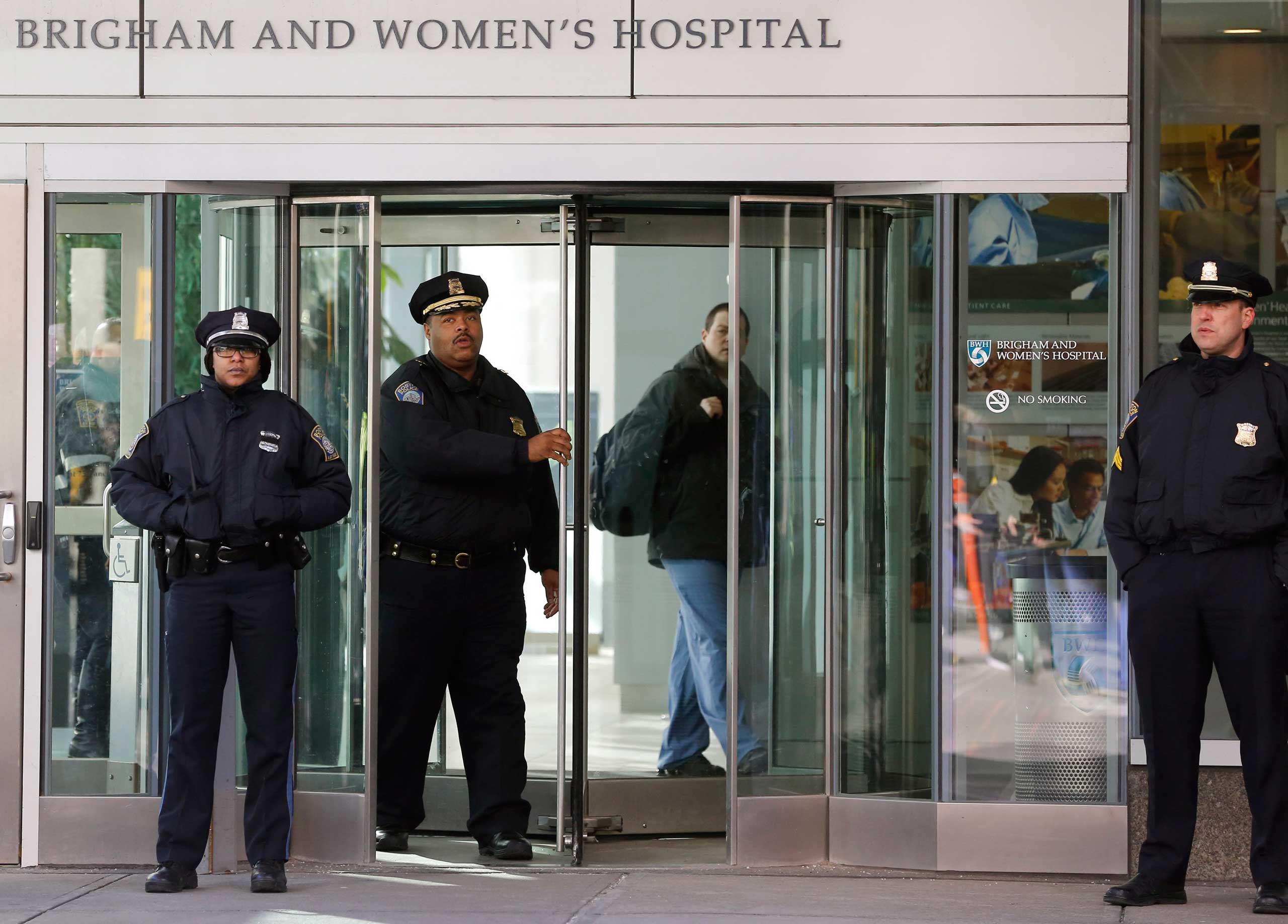 Boston Police Superintendent-in-Chief William Gross, center left, walks through a revolving door as he departs the Shapiro building at Brigham and Women's Hospital, Jan. 20, 2015 in Boston. (Steven Senne—AP)