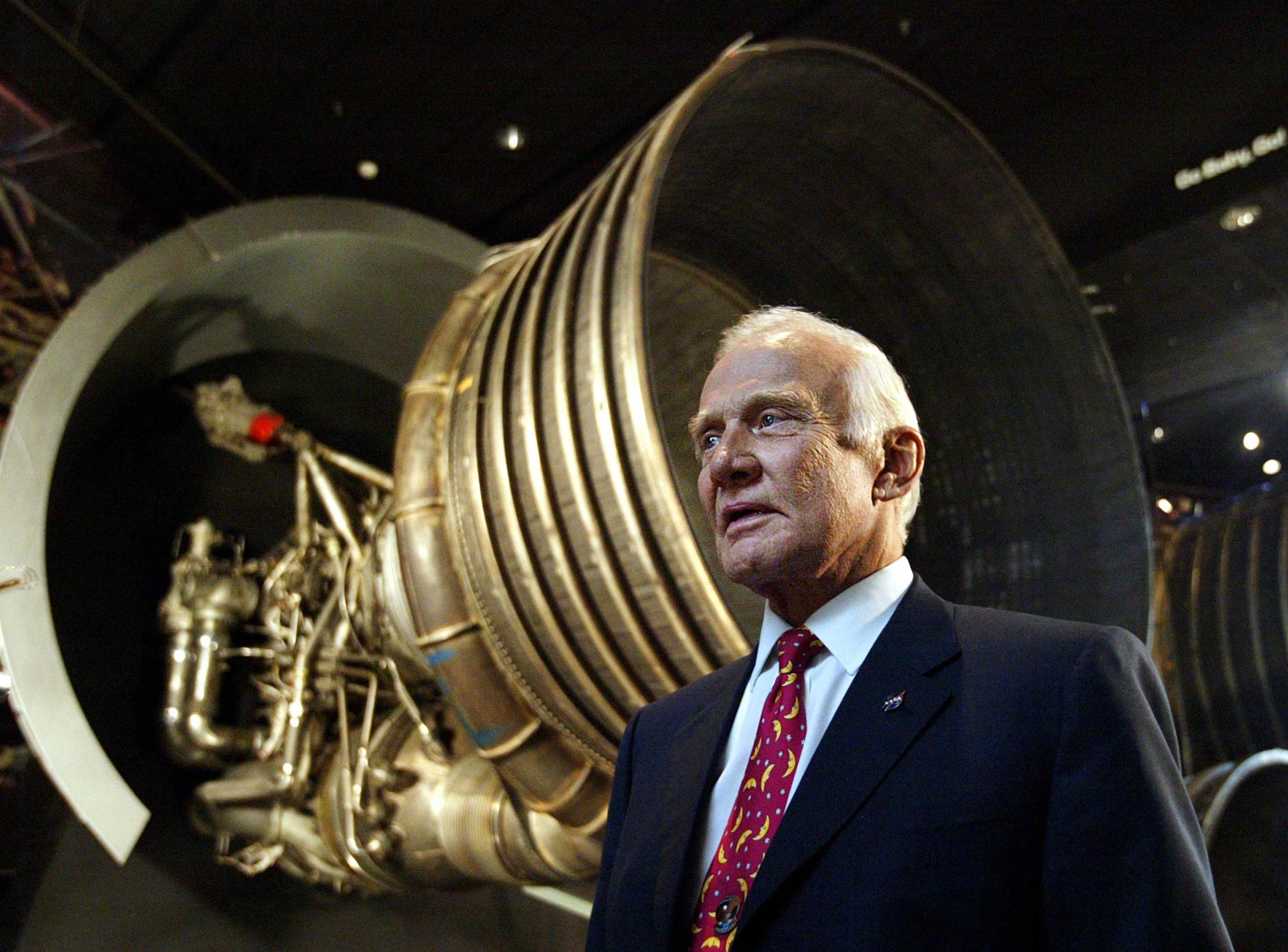 Apollo 11 astronaut Buzz Aldrin, speaks to a reporter in front of the Saturn 5 Aft End, the F-1 rocket engines of the first stage of the Apollo 11/Saturn 5 launch vehicle, Tuesday, July 20, 2004, in Washington. The first moon landing marks its 35th year anniversary. (AP Photo/Manuel Balce Ceneta)