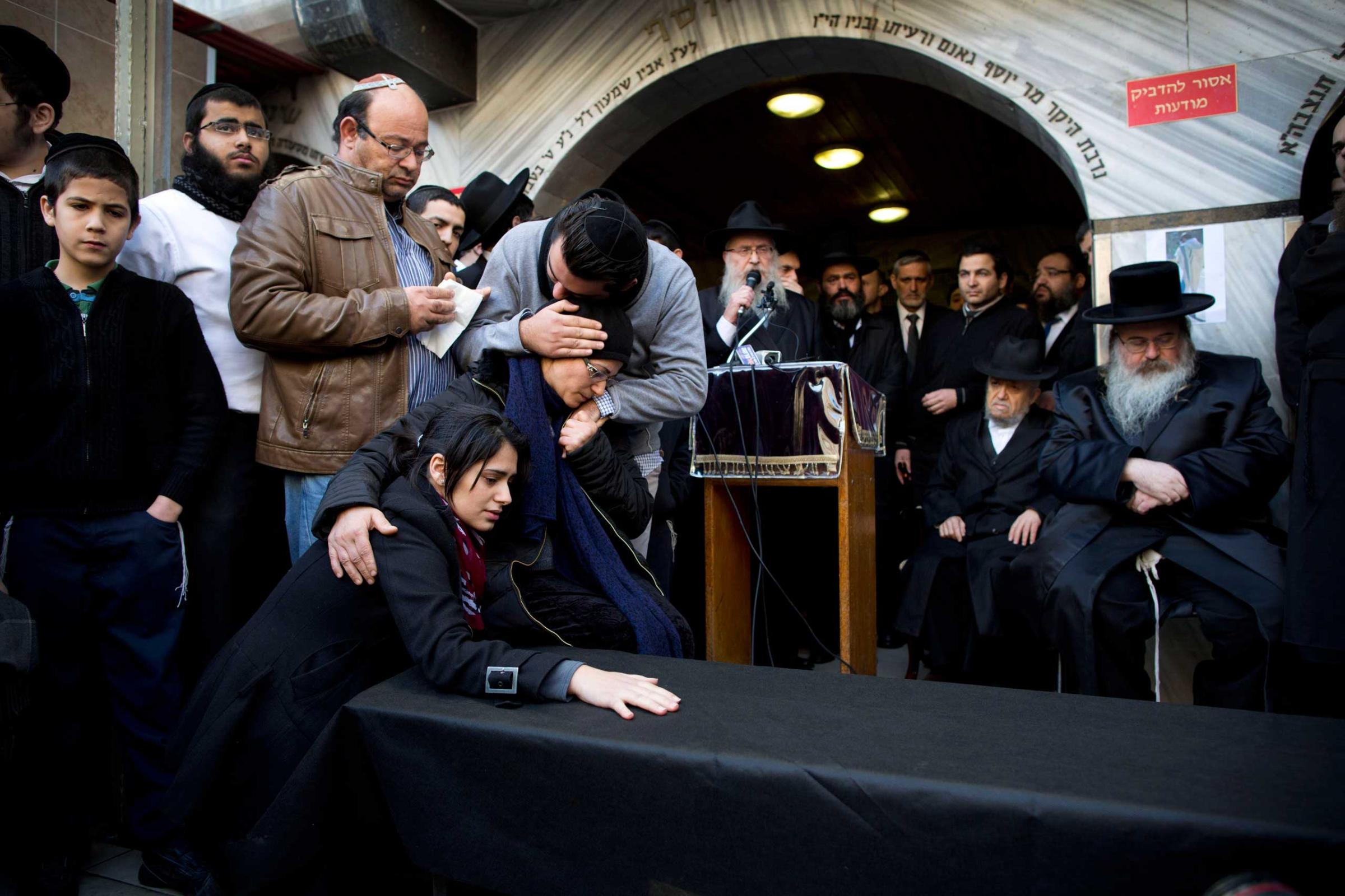 Family and relatives of French Jew Yoav Hattab, a victim of the attack on a kosher grocery store in Paris, gather around a symbolic coffin for his funeral procession in the city of Bnei Brak near Tel Aviv, Israel, Jan. 13, 2015.
