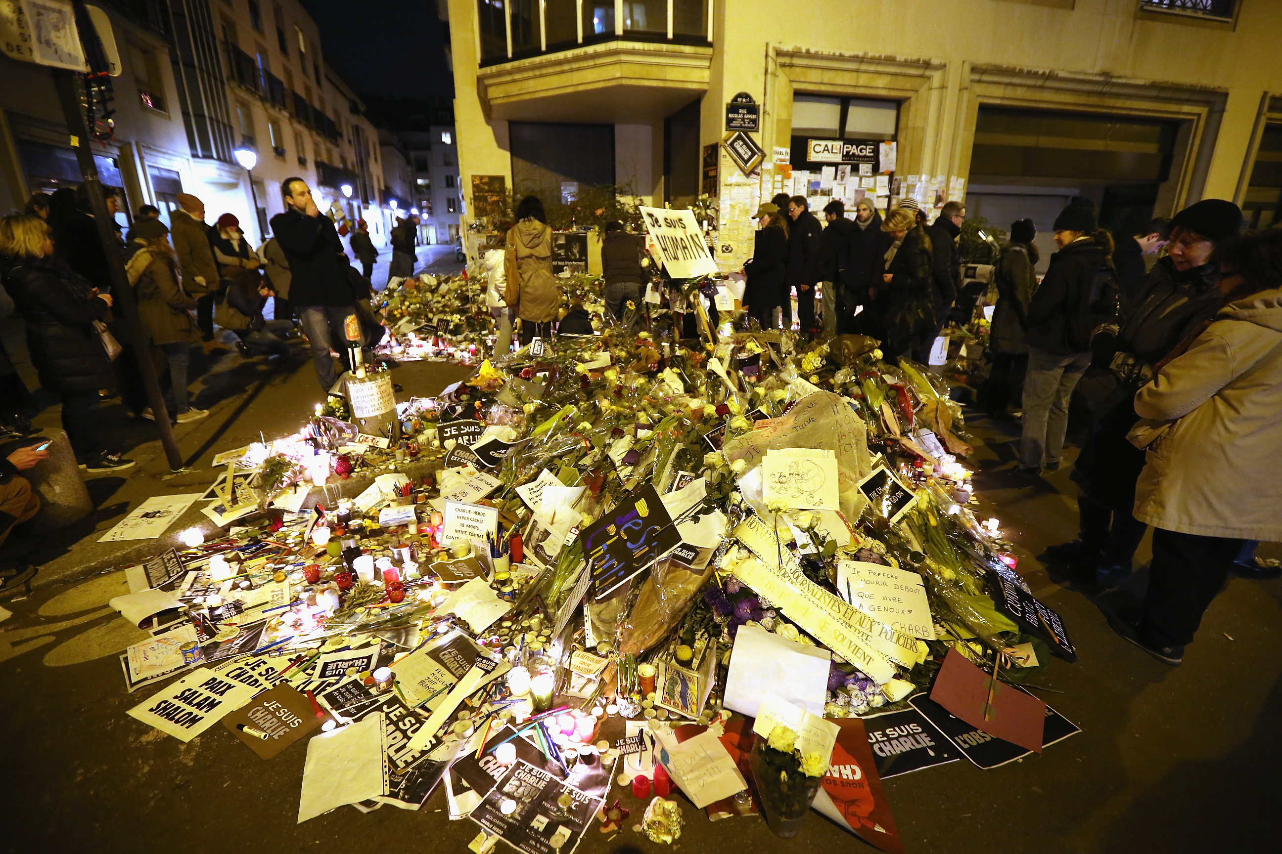 Remembrance: Tributes mounted outside the Charlie Hebdo office after the Jan. 11 unity parade in Paris (Christopher Furlong; 2015 Getty Images)