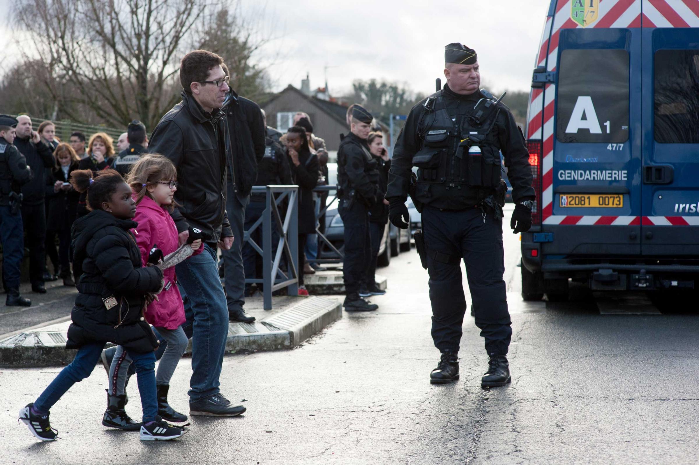 Police forces evacuate the children of the Henry-Dunant primary school located next to printing company Creation Tendance Decouverte CTD, where the two Charlie Hebdo gunmen are detaining a hostage, in Dammartin-en-Goele, north of Paris, France on Jan. 9, 2015.
