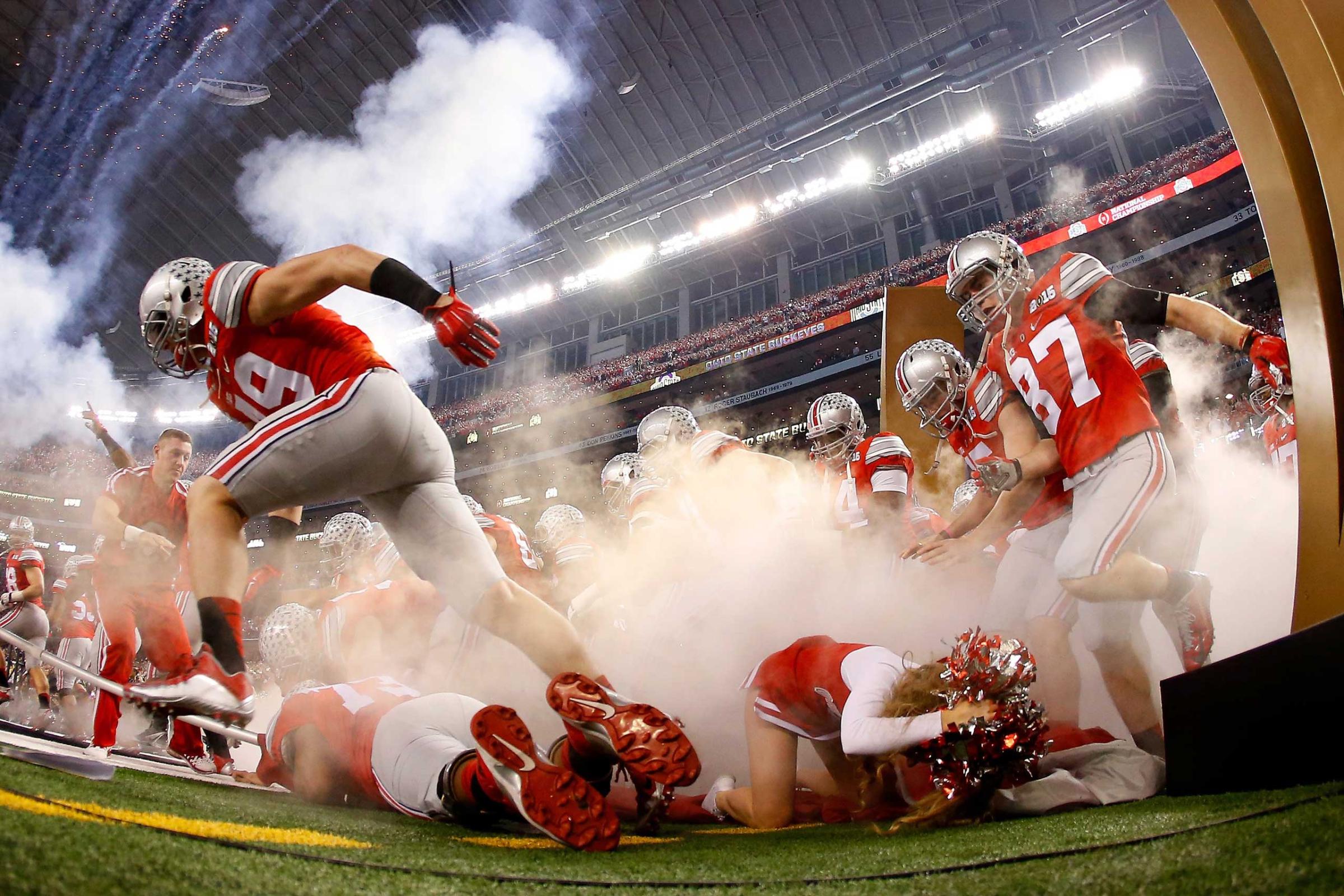 An Ohio State Buckeyes cheerleader falls as the Buckeyes run out to the field before the College Football Playoff National Championship Game at AT&T Stadium on Jan. 12, 2015 in Arlington, Texas.