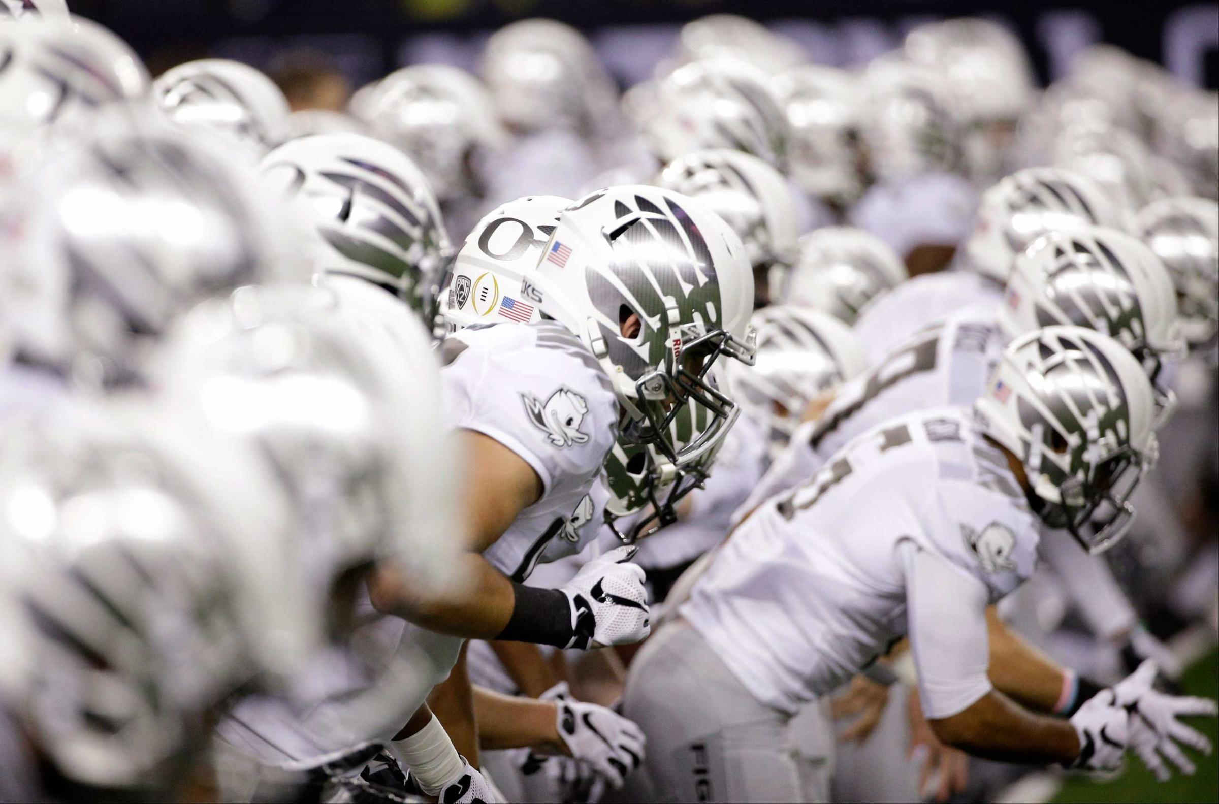 Oregon players warm up before the NCAA college football playoff championship game against Ohio State on Jan. 12, 2015, in Arlington, Texas.