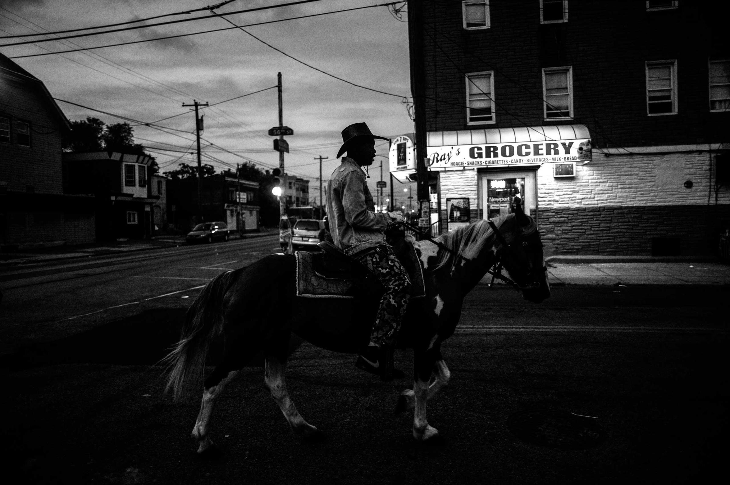 Shahir Drayton, 17, rides his horse back to the stables after a ride through the streets of southwest Philadelphia.