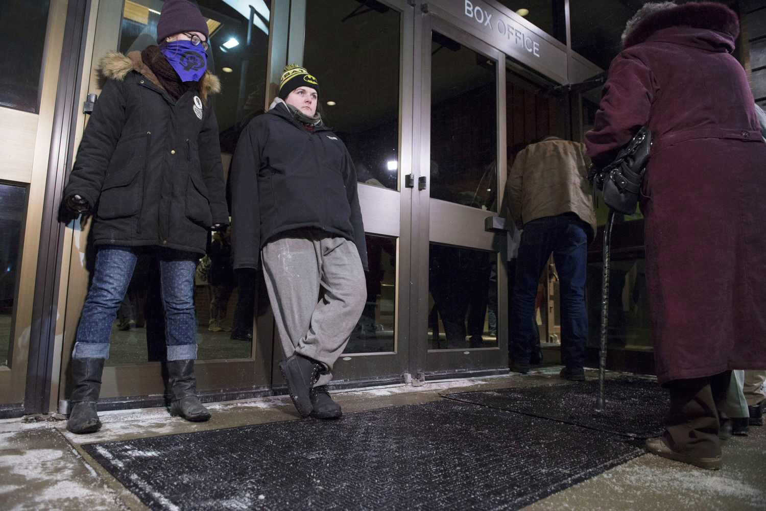 Protesters stand against doors at the entrance to the Centre in the Square theater in Kitchener, Ontario, Canada on Jan. 7, 2015 to protest Bill Cosby. (Hannah Yoon — AP)