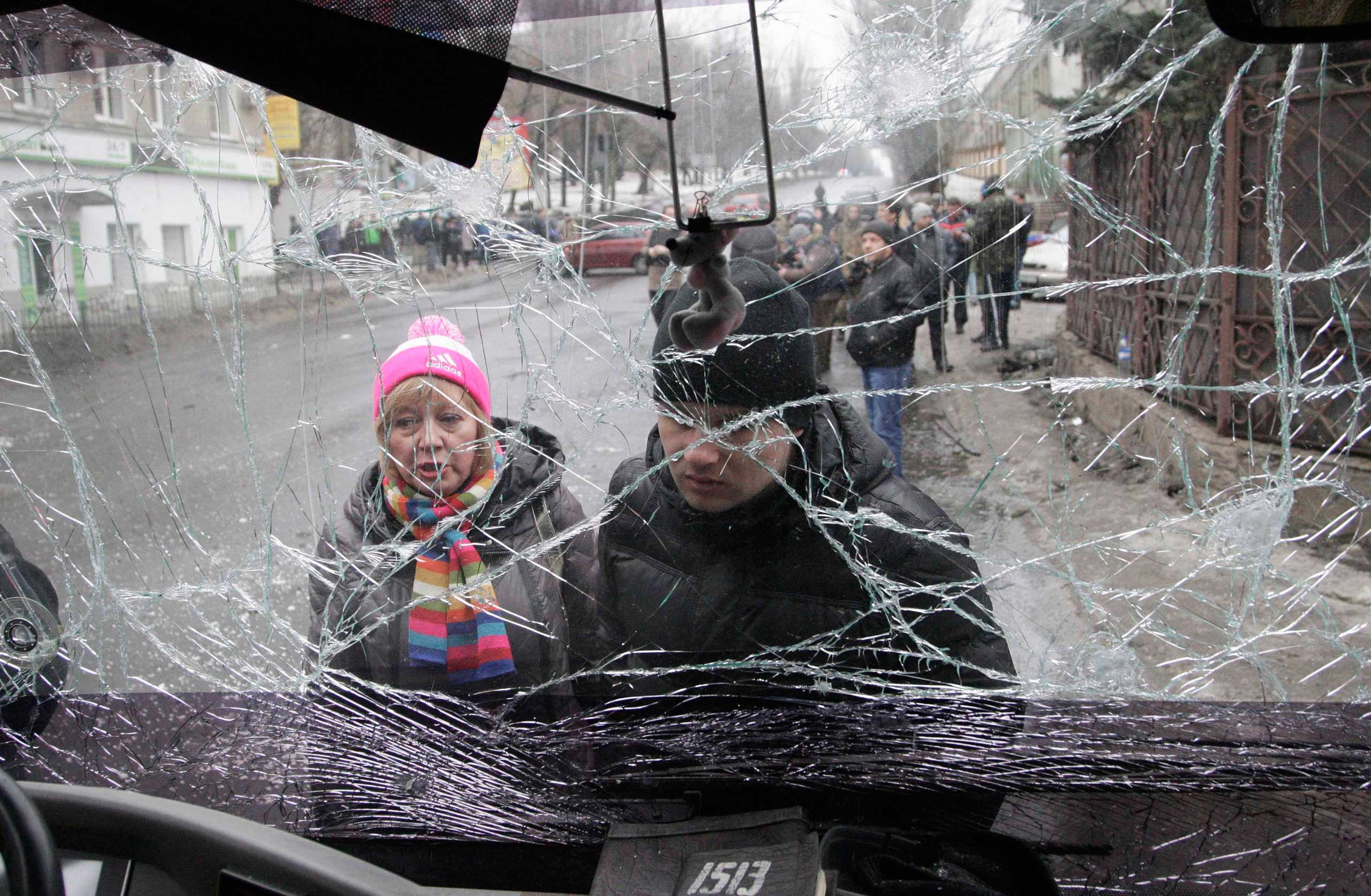 People look through the front windshield of a damaged trolleybus in Donetsk, Jan. 22, 2015. (Reuters)