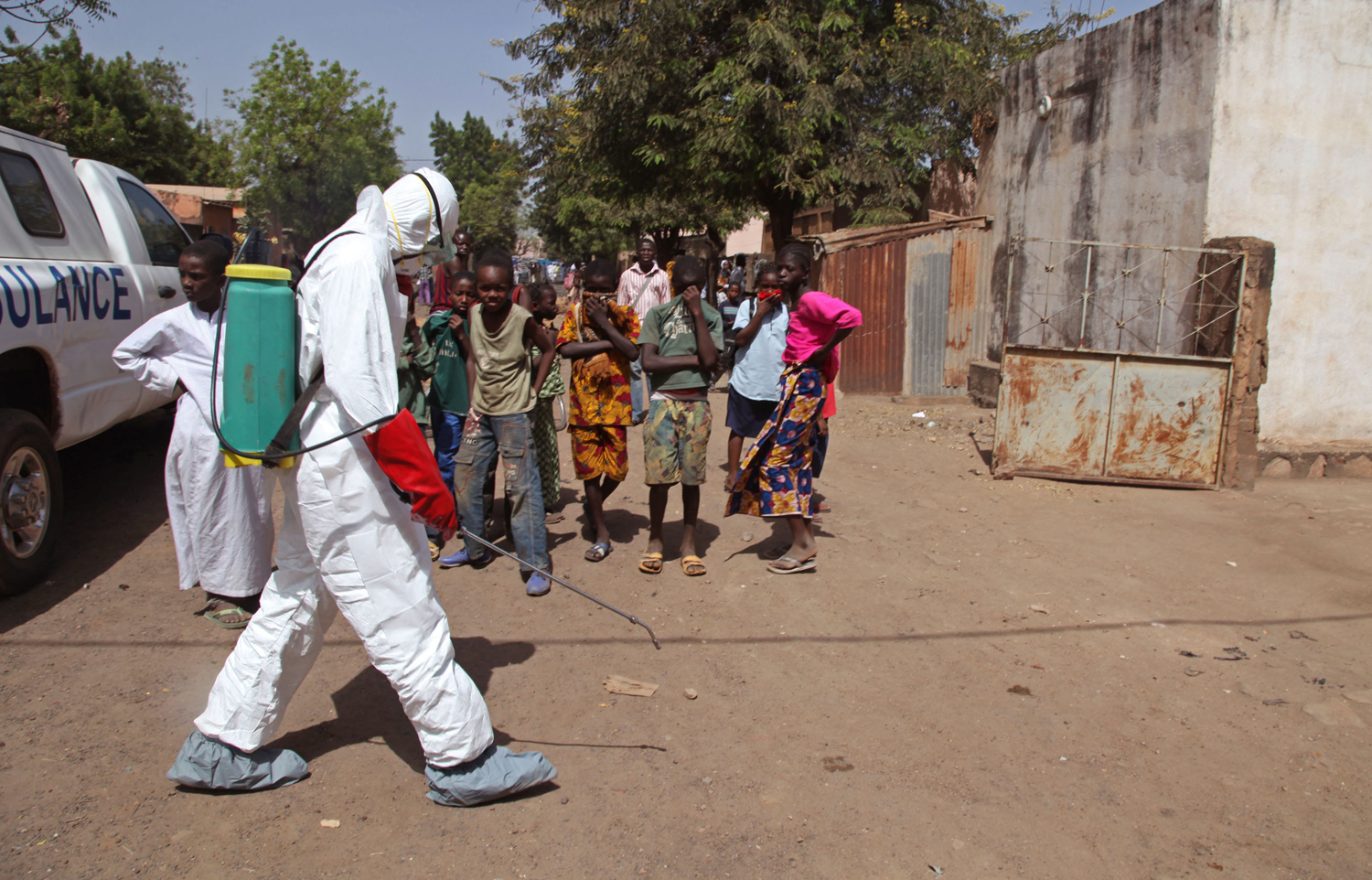 A health worker sprays disinfectants near a mosque, after the body of a man suspected of dying from the Ebola virus was washed inside before being buried  in Bamako, Mali (Baba Ahmed—AP)