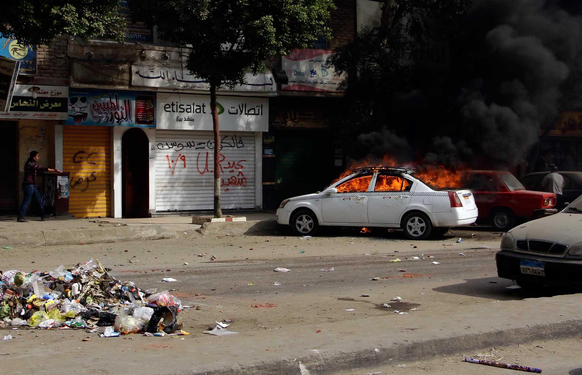 A taxi burns during clashes with Egyptian security forces in the Cairo suburb of Matariyah, Jan. 25, 2015.