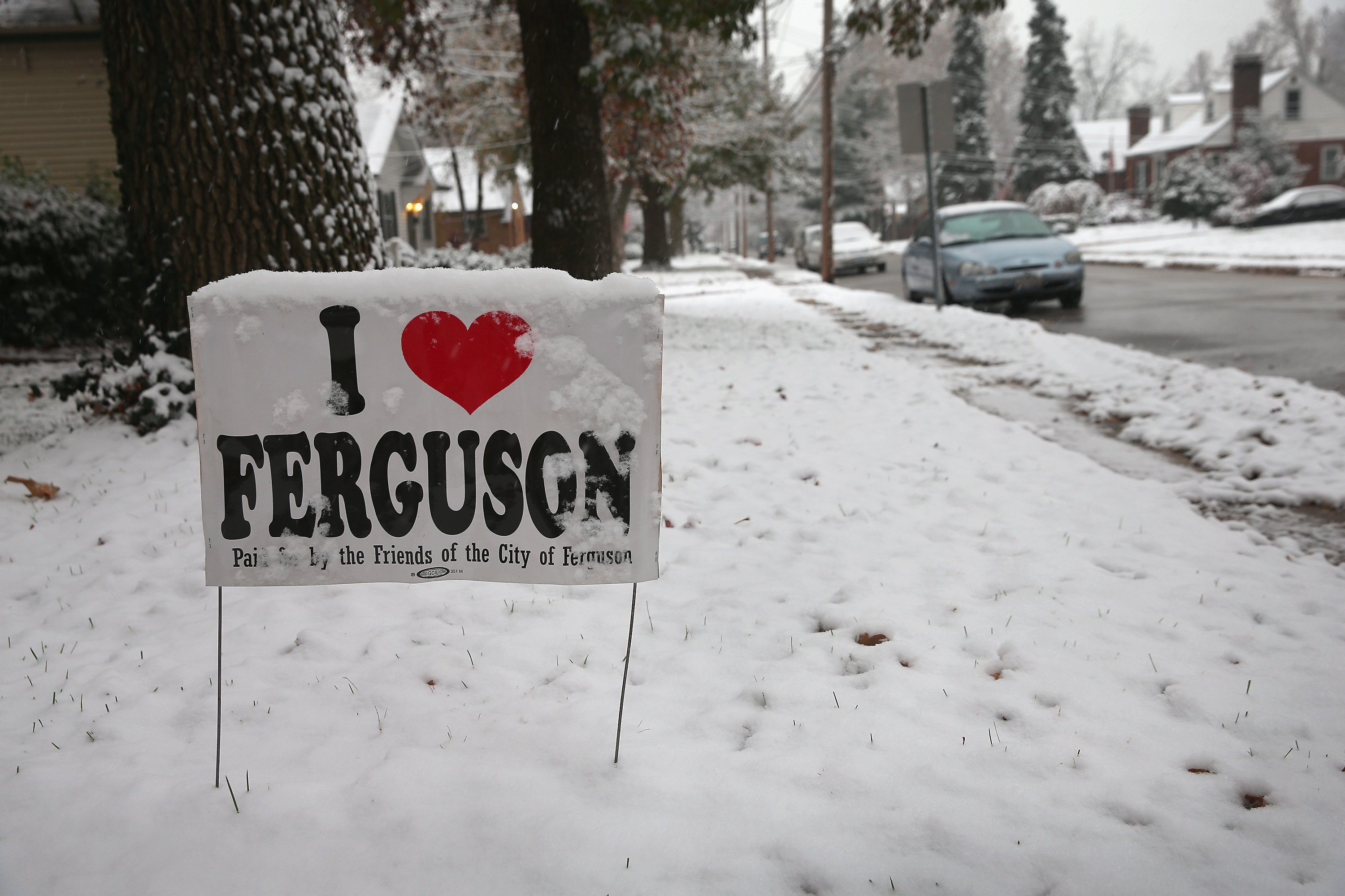 Snow covers a yard sign placed outside a home near the police station on Nov. 16, 2014 in Ferguson, Missouri. (Scott Olson—Getty Images)