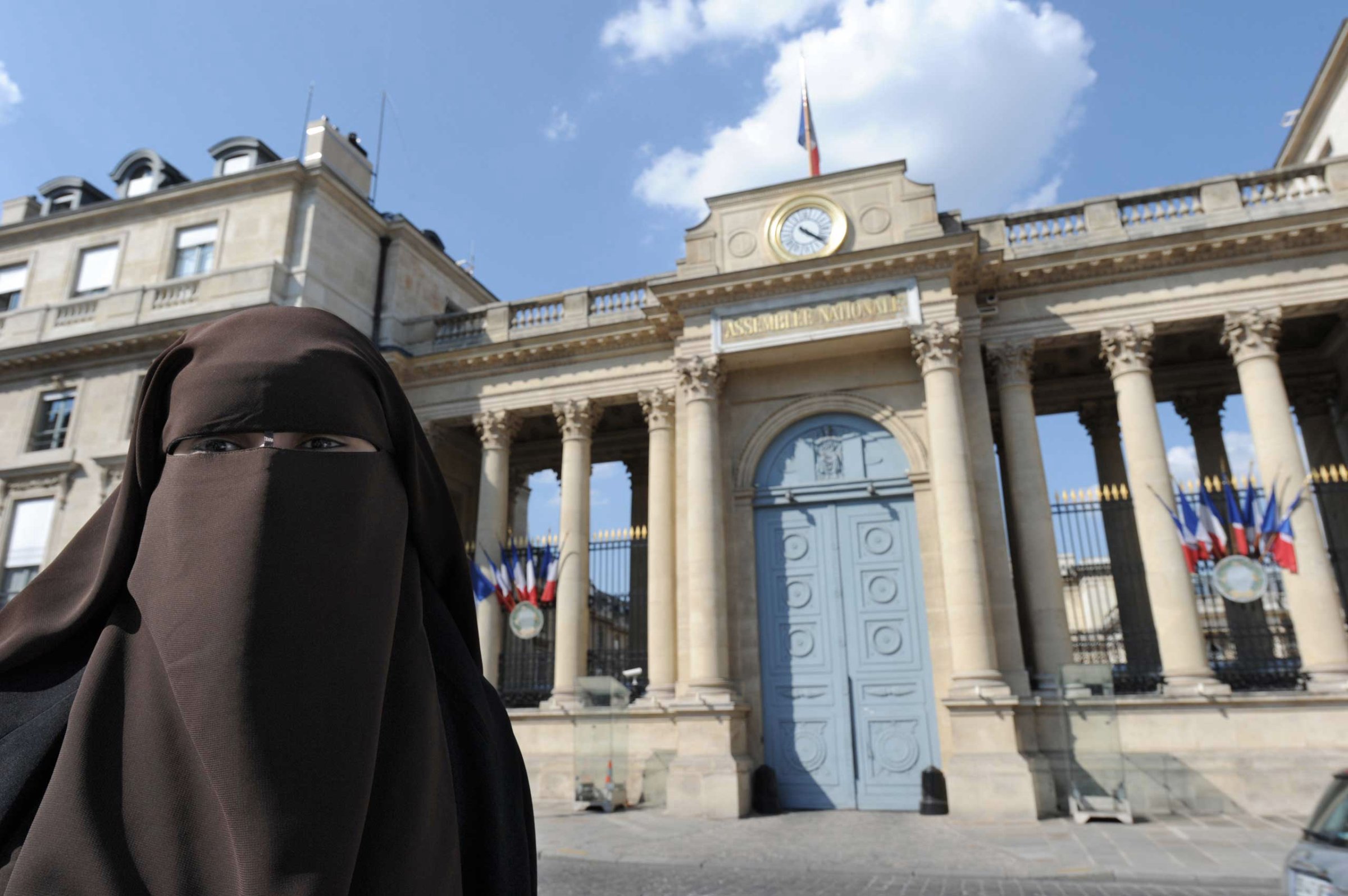 A Niqab veiled woman poses in front of the French National Assembly to protest against France's ban on wearing full-face niqab veils in public, in Paris in 2011.