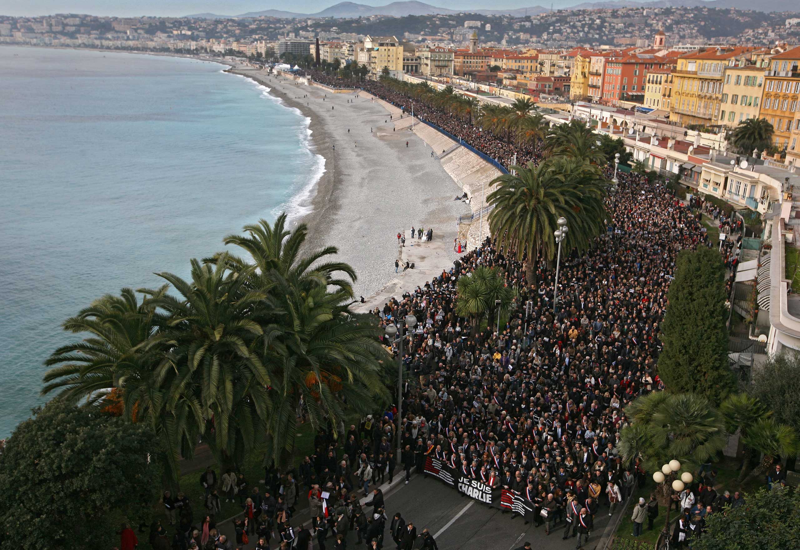 People take part in a silent procession for victims of the shooting at the satirical newspaper Charlie Hebdo, Jan. 10, 2015, in Nice, southeastern France.