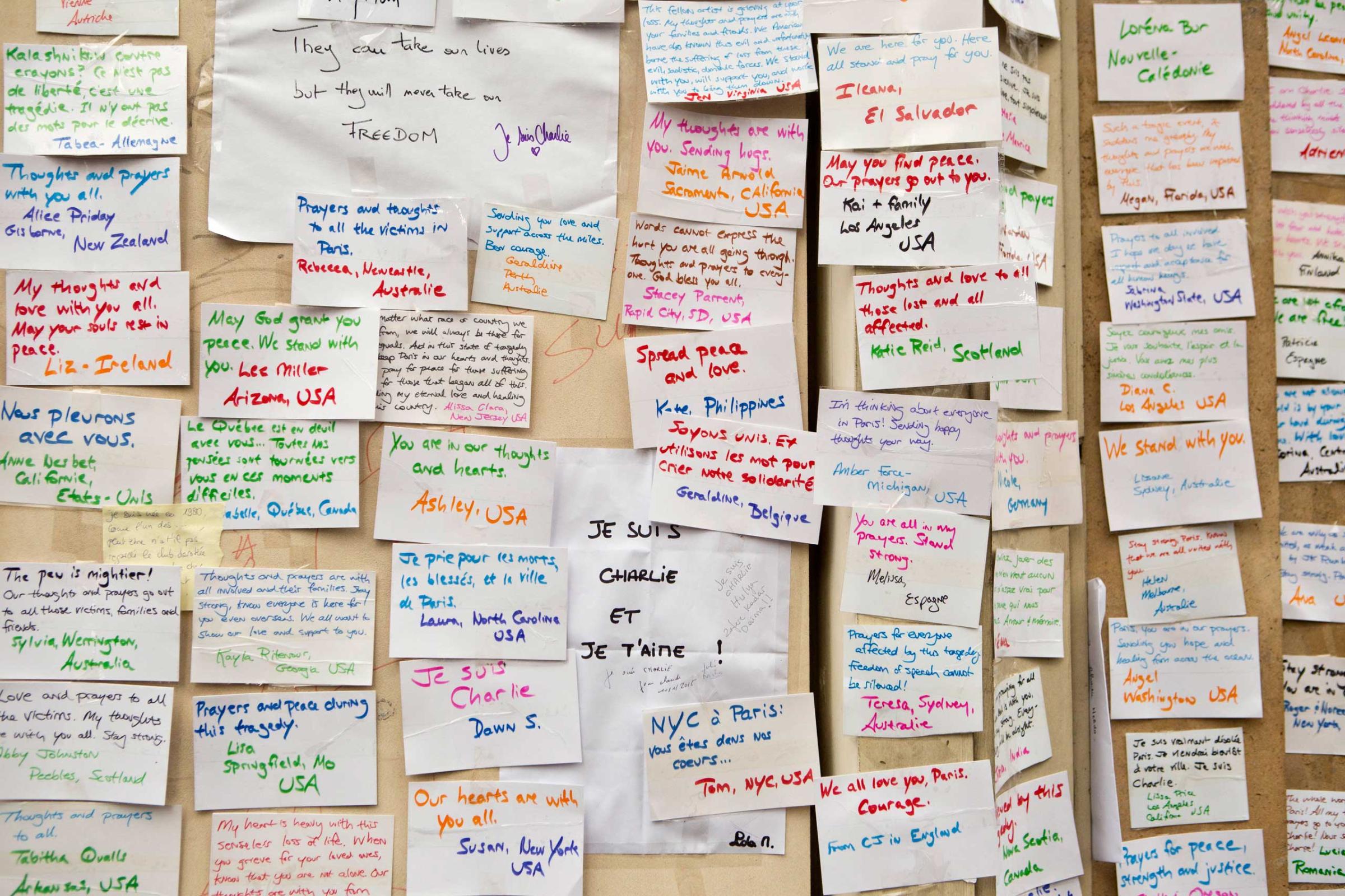 Messages left by people visiting a makeshift memorial are pasted to a wall near the offices of French satirical newspaper Charlie Hebdo in Paris, Jan. 10, 2015.