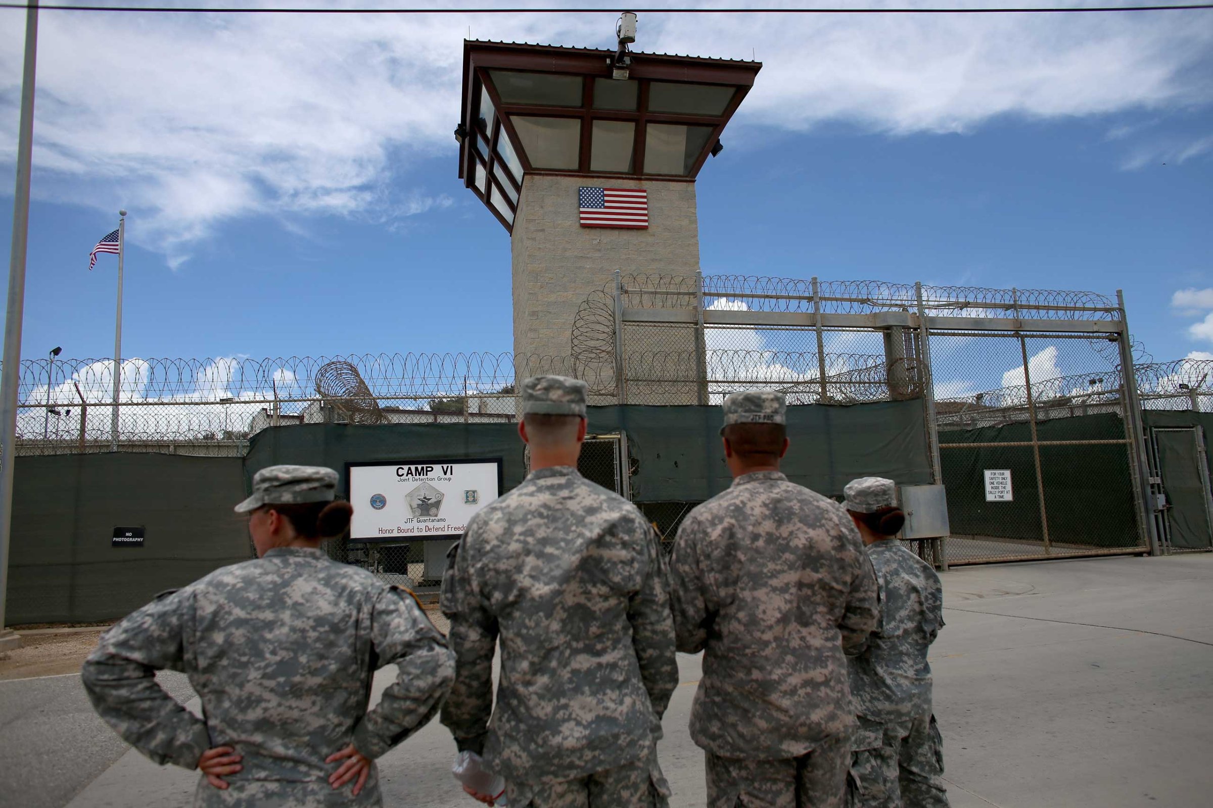 Military officers stand at the entrance to Camp VI and V at the U.S. military prison for 'enemy combatants' on June 25, 2013 in Guantanamo Bay, Cuba.