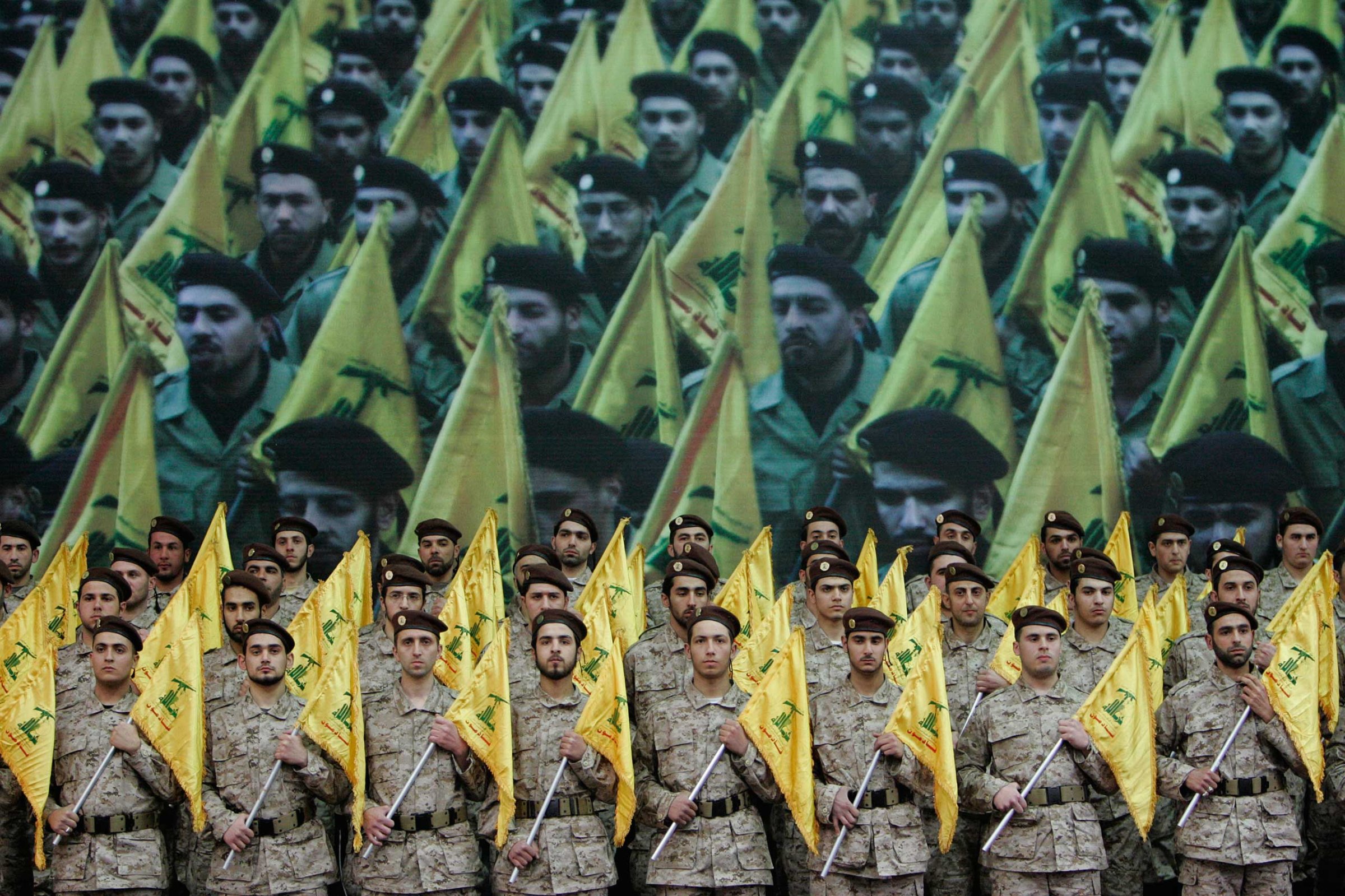 Hezbollah fighters hold their party flags as they attend a rally to commemorate slain top Hezbollah commander Imad Mughniyeh and two other leaders, Abbas Musawi and Ragheb Harb, in the Shiite suburb of Beirut, Feb. 22, 2008.