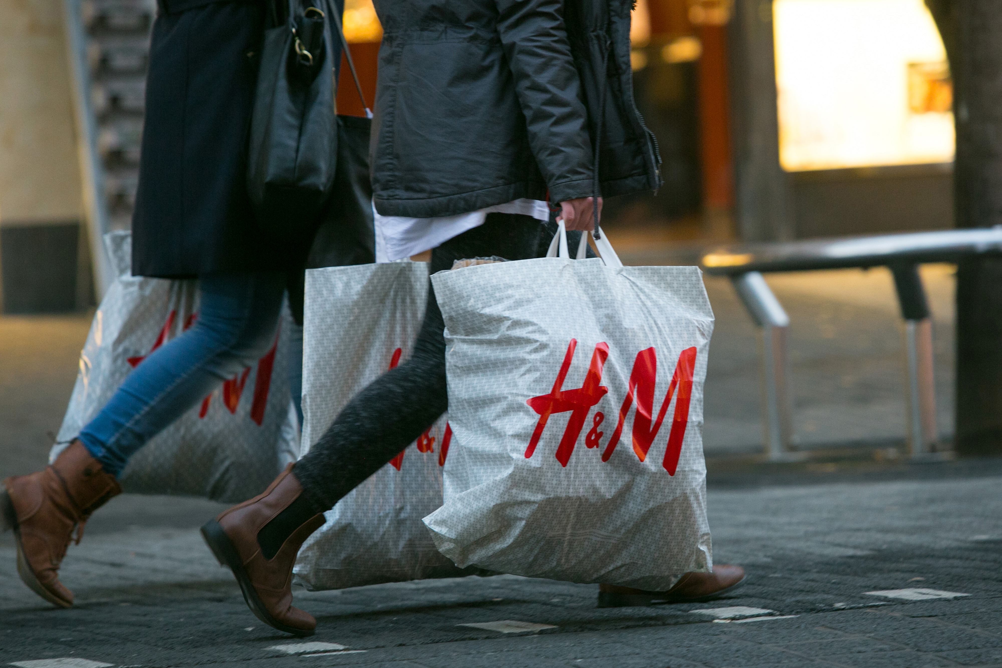 Pedestrians carry Hennes &amp; Mauritz AB (H&amp;M) branded shopping bags in Mannheim, Germany, on Tuesday, Jan. 20, 2015. (Bloomberg—Getty Images)