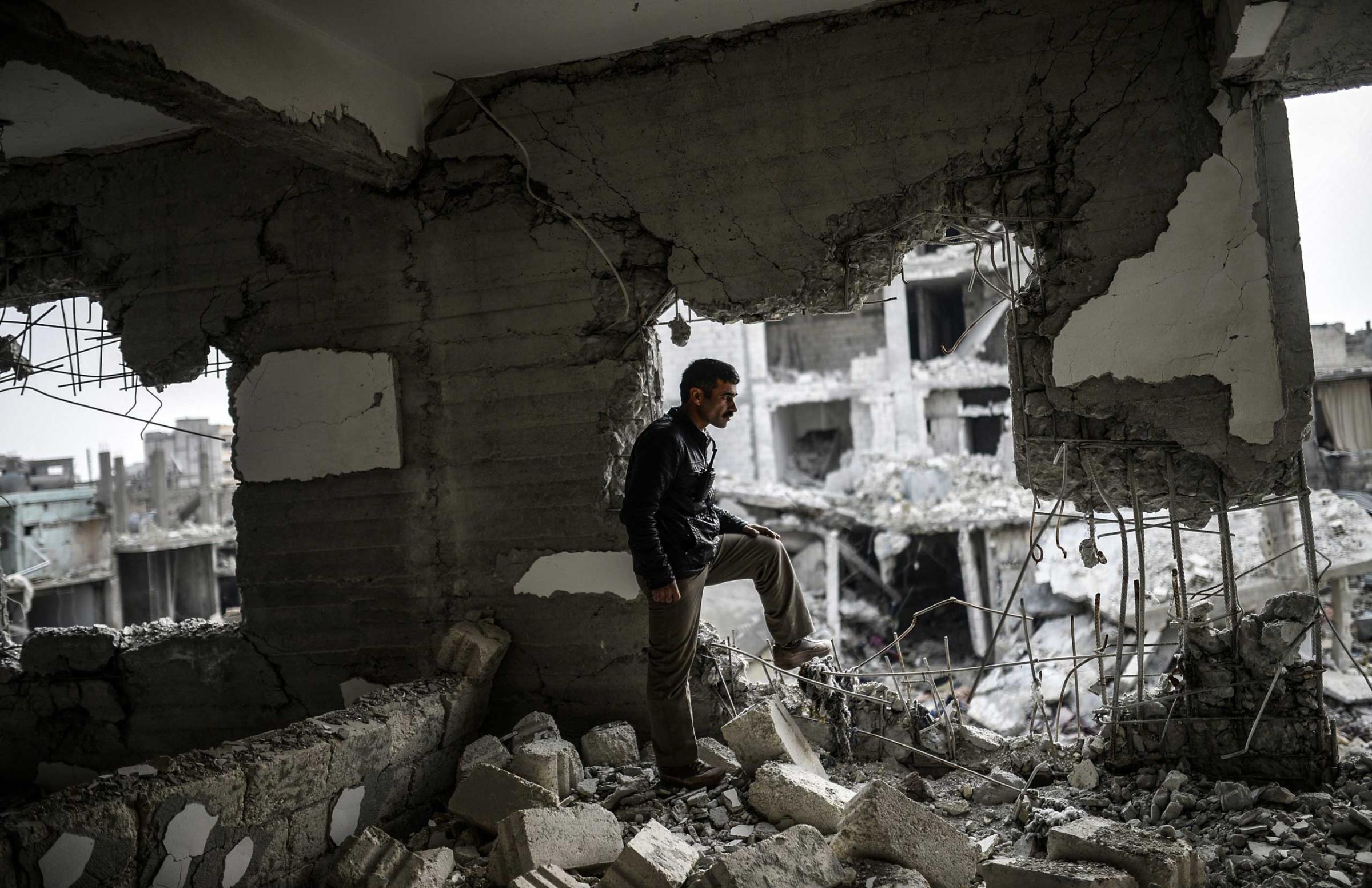 A Kurdish man stands in a destroyed building in the center of the Syrian border town of Kobani on Jan. 28, 2015.
