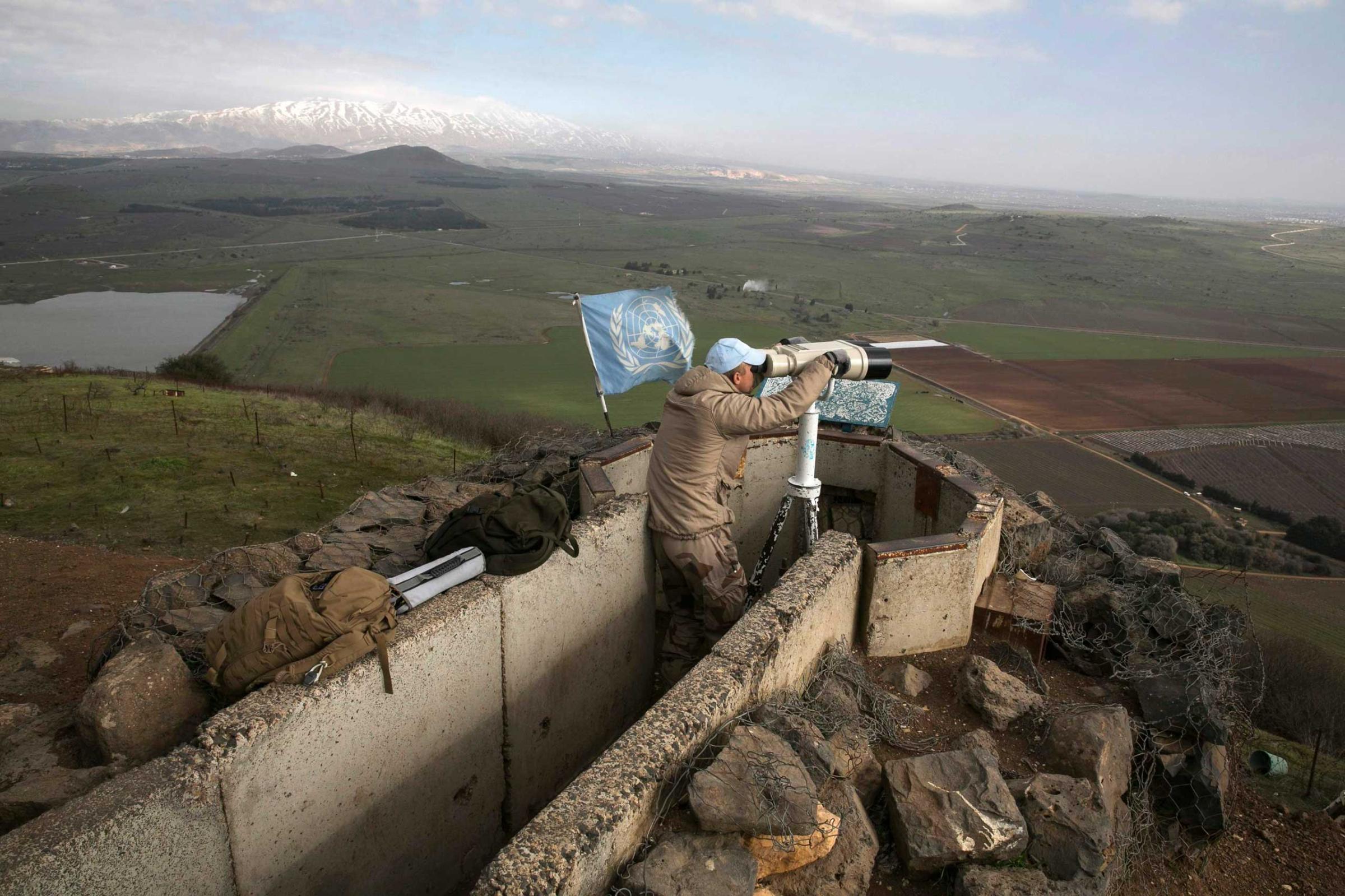 A member of the United Nations Disengagement Observer Force looks through binoculars at Mount Bental, an observation post in the Israeli occupied Golan Heights, Jan. 28, 2015.
