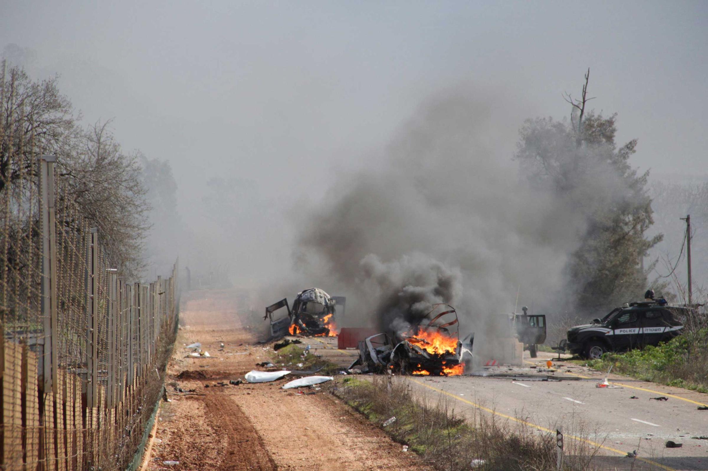 Burning vehicles are seen near the village of Ghajar on Israel's border with Lebanon, Jan. 28, 2015.