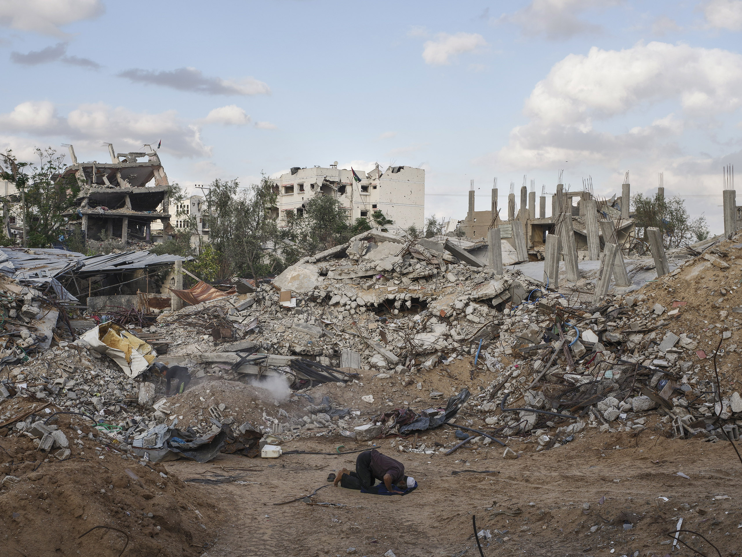 A Palestinian man prays in a Gaza neighborhood destroyed during the war last year between Hamas and Israel.From  The Path to Peace.  January 19, 2015 issue.