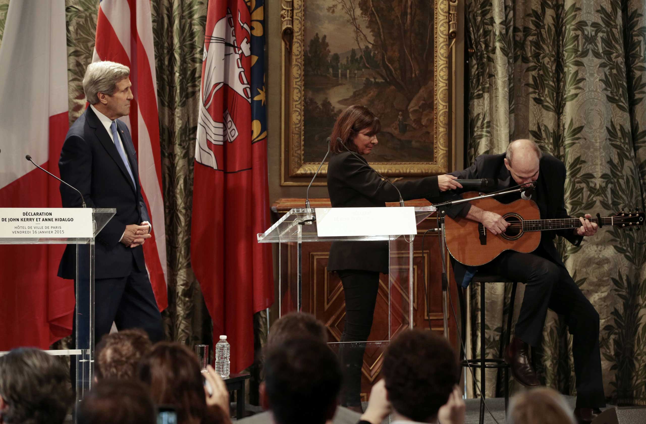 Paris Mayor Anne Hidalgo (C) and US Secretary of State John Kerry (L) listen to US musician James Taylor at Paris City Hall on January 16, 2015. (Joel Saget—AFP/Getty Images)