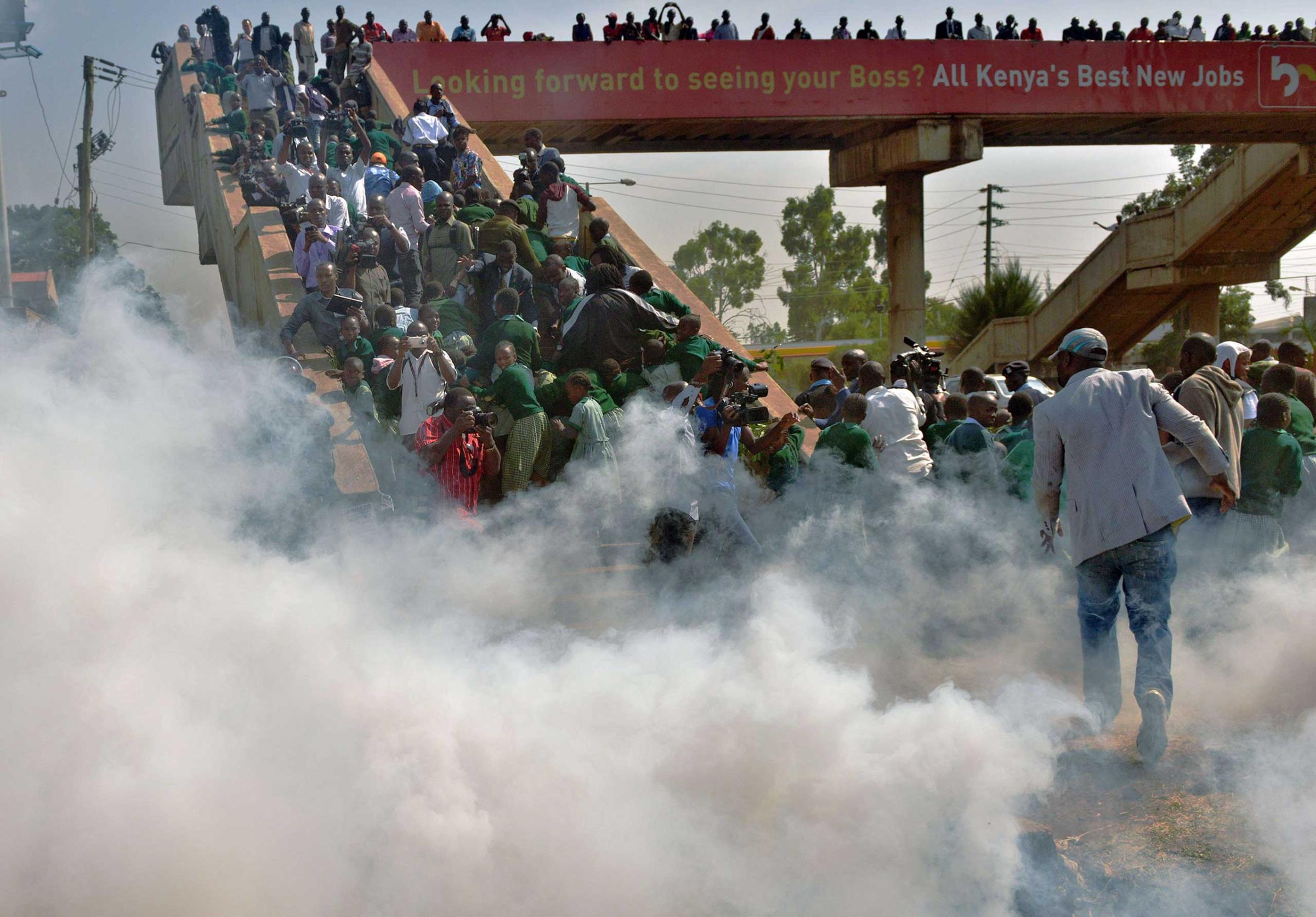 School children from the Lang'ata road primary school scramble up a bridge on Jan. 19, 2015 in Nairobi to escape tear gas.
