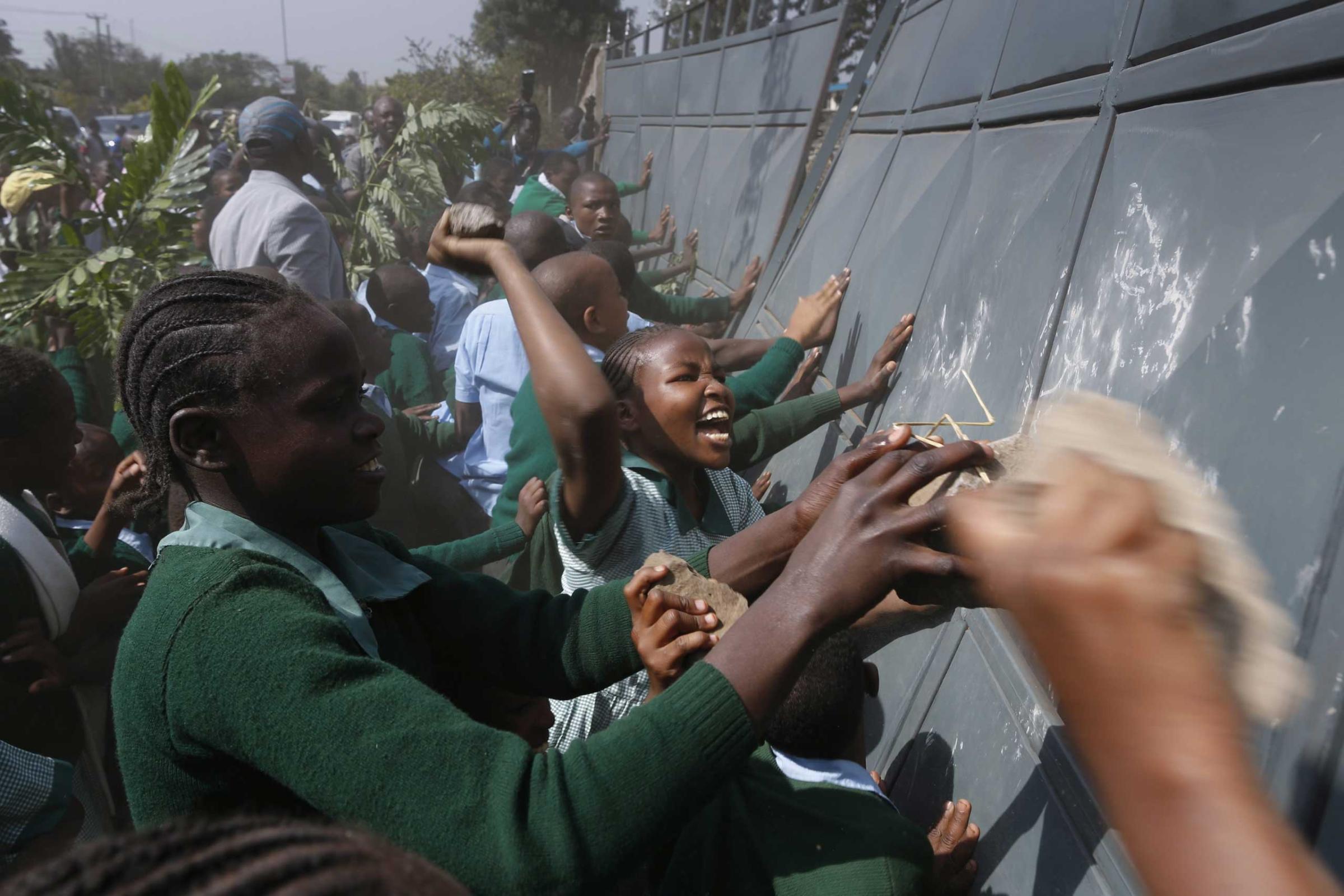 School children push the fence to enter the school playground during a protest against alleged land grabbing at Langata Road Primary School in Nairobi, Jan. 19, 2015.