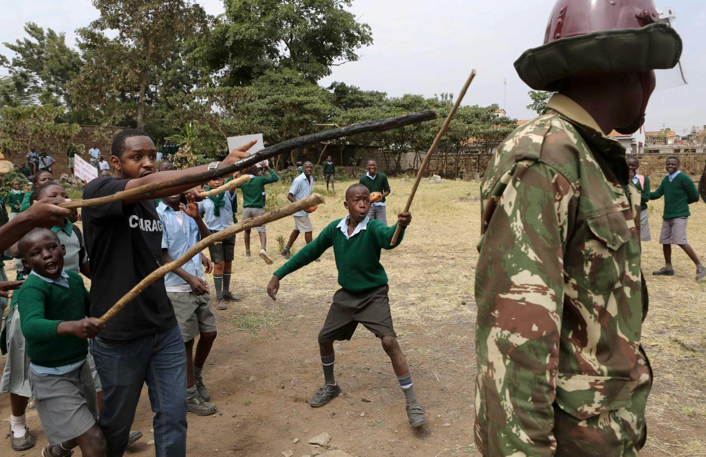Kenyan school pupils and activists challenge riot police during a protest against the removal of their school's playground, at the Langata Road Primary School, in Nairobi, Jan. 19, 2015.
