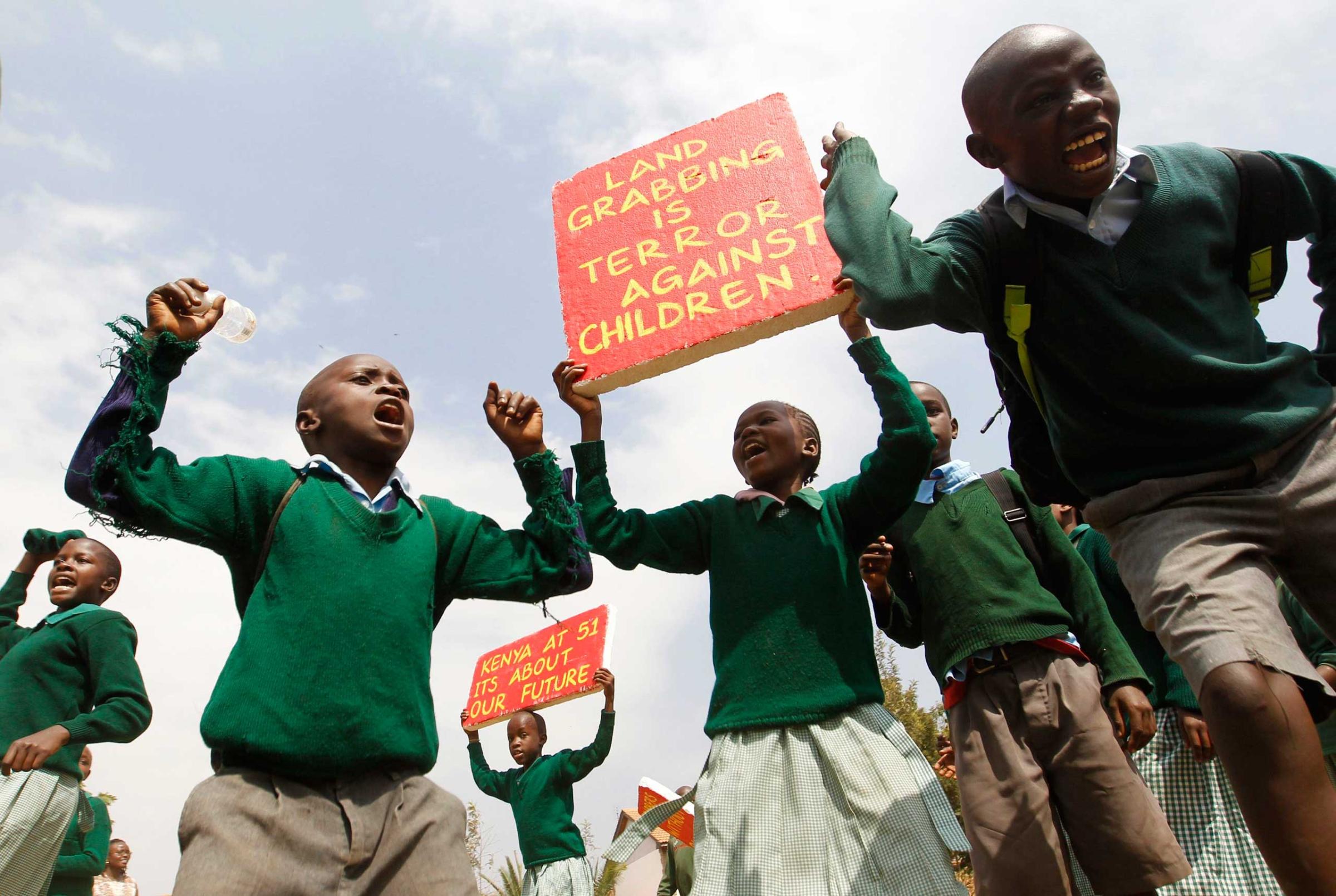 Students from Langata primary school hold placards as they protest against a perimeter wall illegally erected by a private developer around their school playground in Kenya's capital Nairobi, Jan. 19, 2015.
