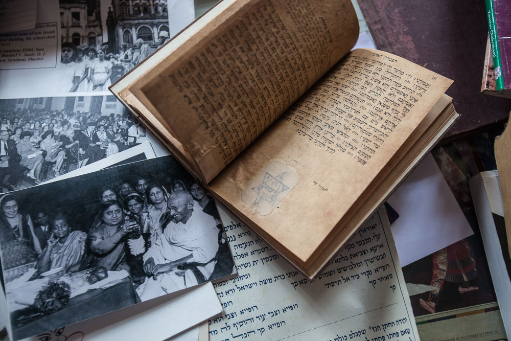 An old prayer book and photographs of the community in its heyday, one of them featuring Mahatma Gandhi.