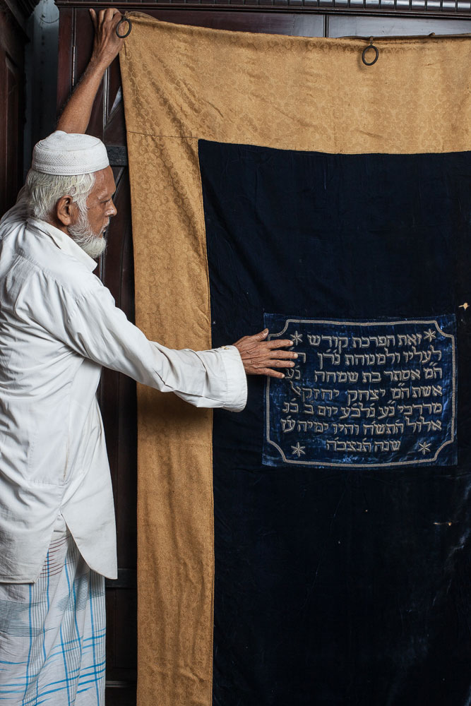 Sk. Nassir, 75, is one of the two Muslim caretakers of the Beth El Synagogue. Here holds one of the parokhets (Torah ark curtains) that once hung inside the synagogue.