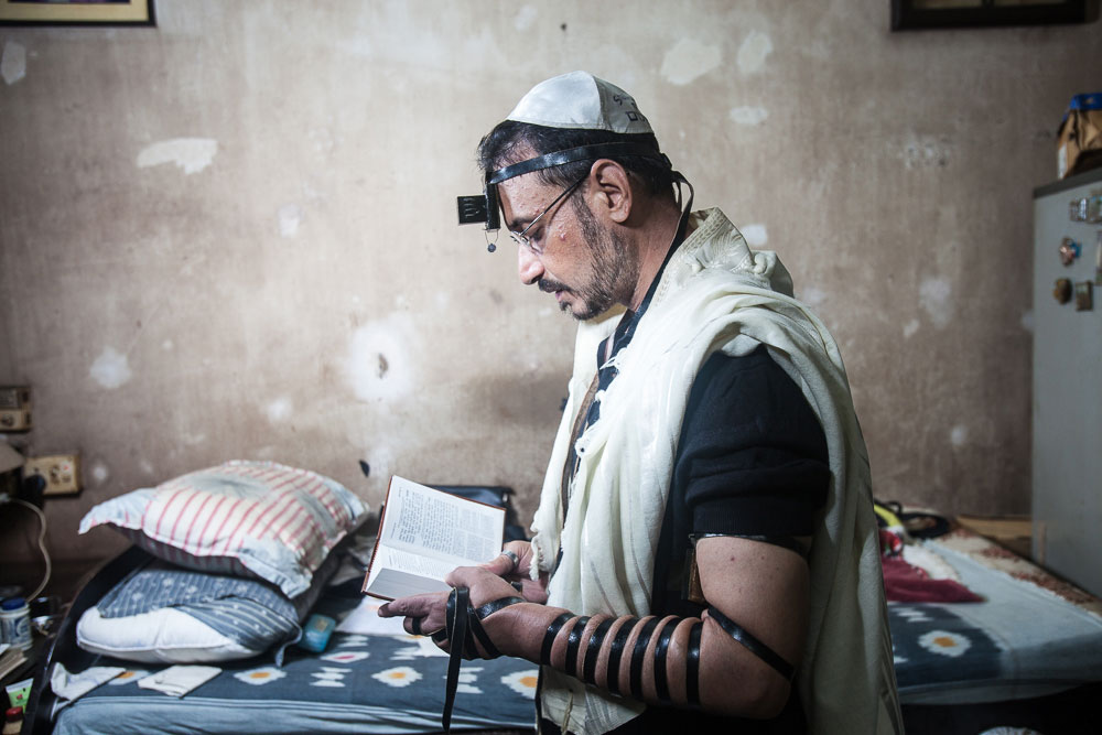 Shalom Israel, the former caretaker of Beth El Synagogue and undertaker of the Jewish cemetery, wearing the Tefillin during a weekday morning prayer in August 2014. He left Calcutta for Israel that December.